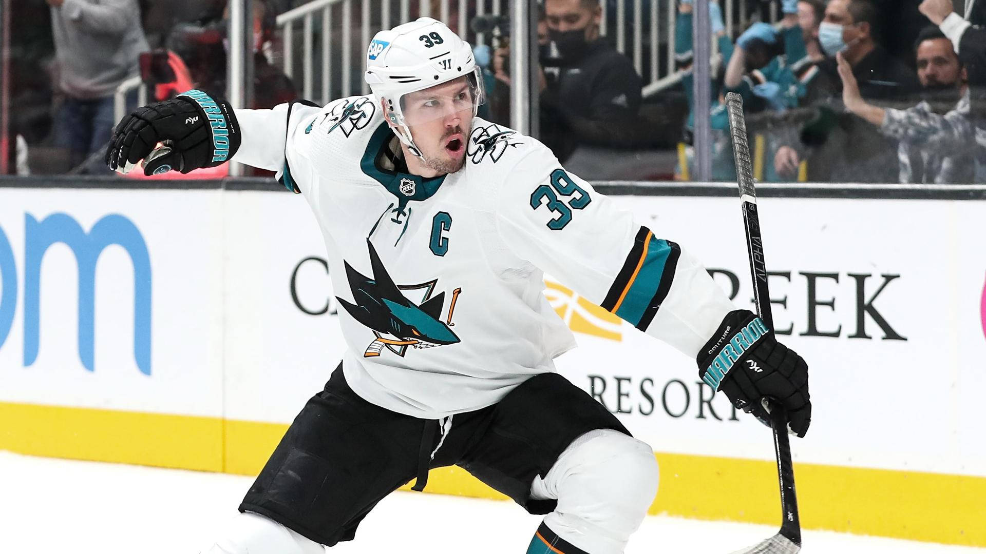 hockey 桌布 壁紙 — 一名身穿白色鯊魚隊球衣、背號39的冰球運動員在比賽中於冰上熱情慶祝。