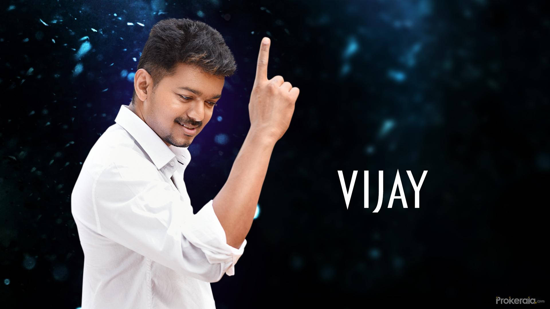 vijay HD 桌布 壁紙 — 一名身穿白襯衫的男子微笑著向上指，背景是帶有發光粒子的黑暗宇宙。