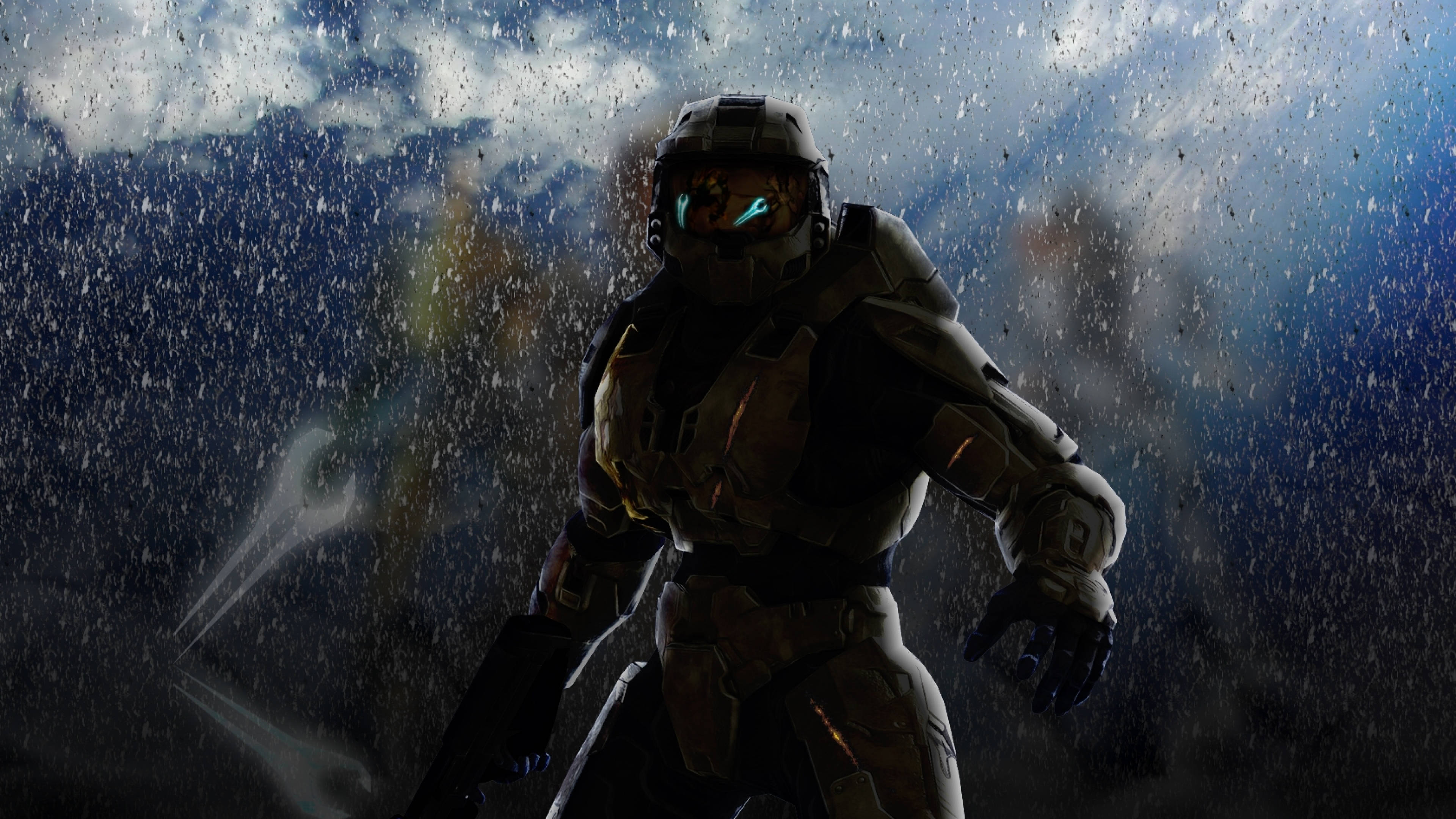 Master Chief 桌布 壁紙 — 一名身穿盔甲的斯巴達戰士在暴雨中站立，藍色發光面罩映襯著黑暗的暴風雨天空。