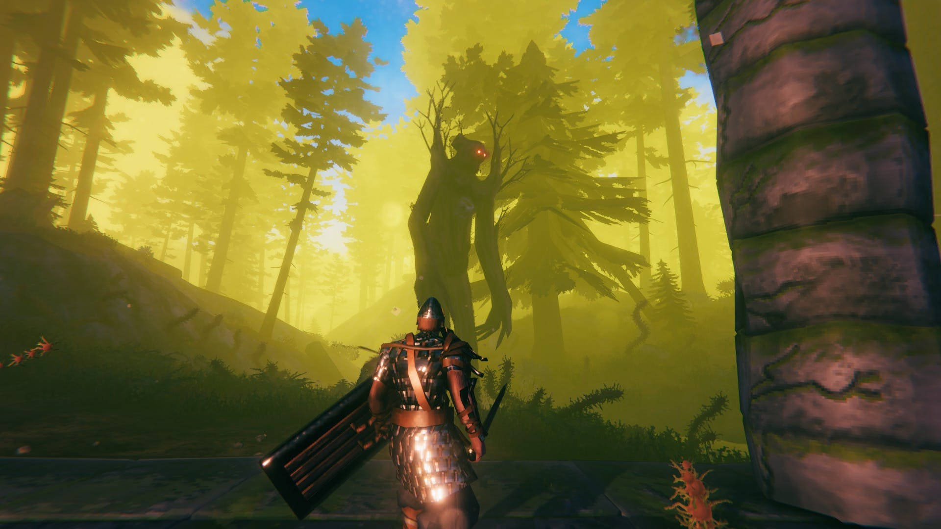 Valheim 桌布 壁紙 — 一名身穿盔甲的騎士站在一棵高聳的樹前，樹上有發光的紅色眼睛，周圍是迷霧籠罩的黃色森林。