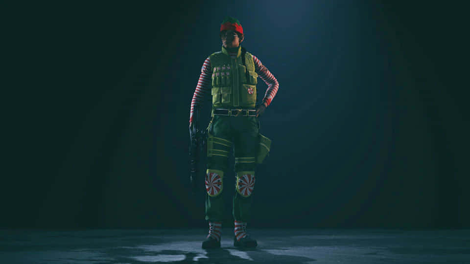 Rainbow Six Siege Ash 桌布 壁紙 — 一名身穿節日綠色和紅色假期裝備的士兵在黑暗的攝影棚中自信地站立，伴隨著戲劇性的聚光燈。
