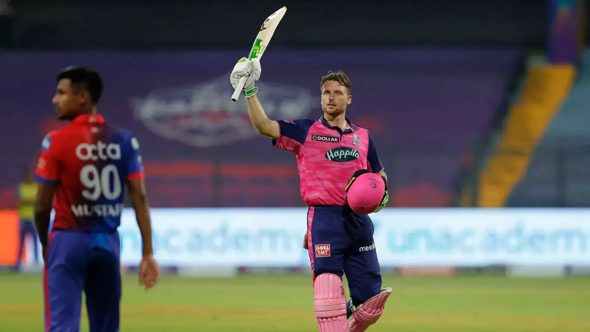 jos buttler 桌布 壁紙 — 一名身穿粉紅色制服的板球運動員在燈火通明的體育場上高舉球棒，勝利慶祝。