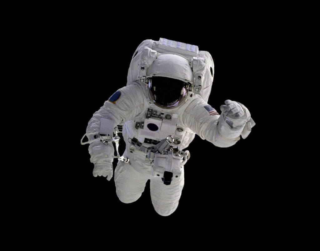 Astronaut In Space 桌布 壁紙 — 一名身穿精細白色太空衣的太空人，在漆黑的太空真空中失重漂浮。