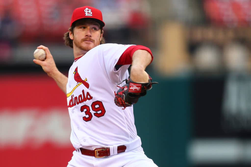 棒球 桌布 壁紙 — 一名身穿紅白 Cardinals 球衣的棒球投手，在日間比賽中全神貫注地投球。
