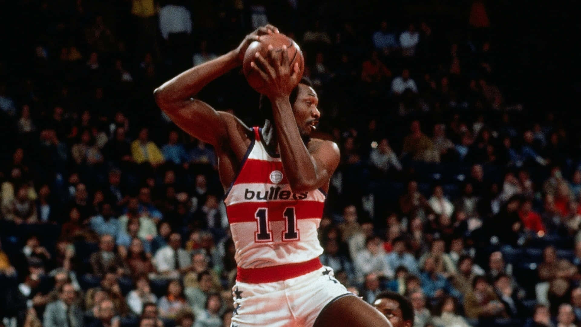 身穿Bullets球衣11號的籃球運動員在比賽中投籃。 — NBA 壁紙