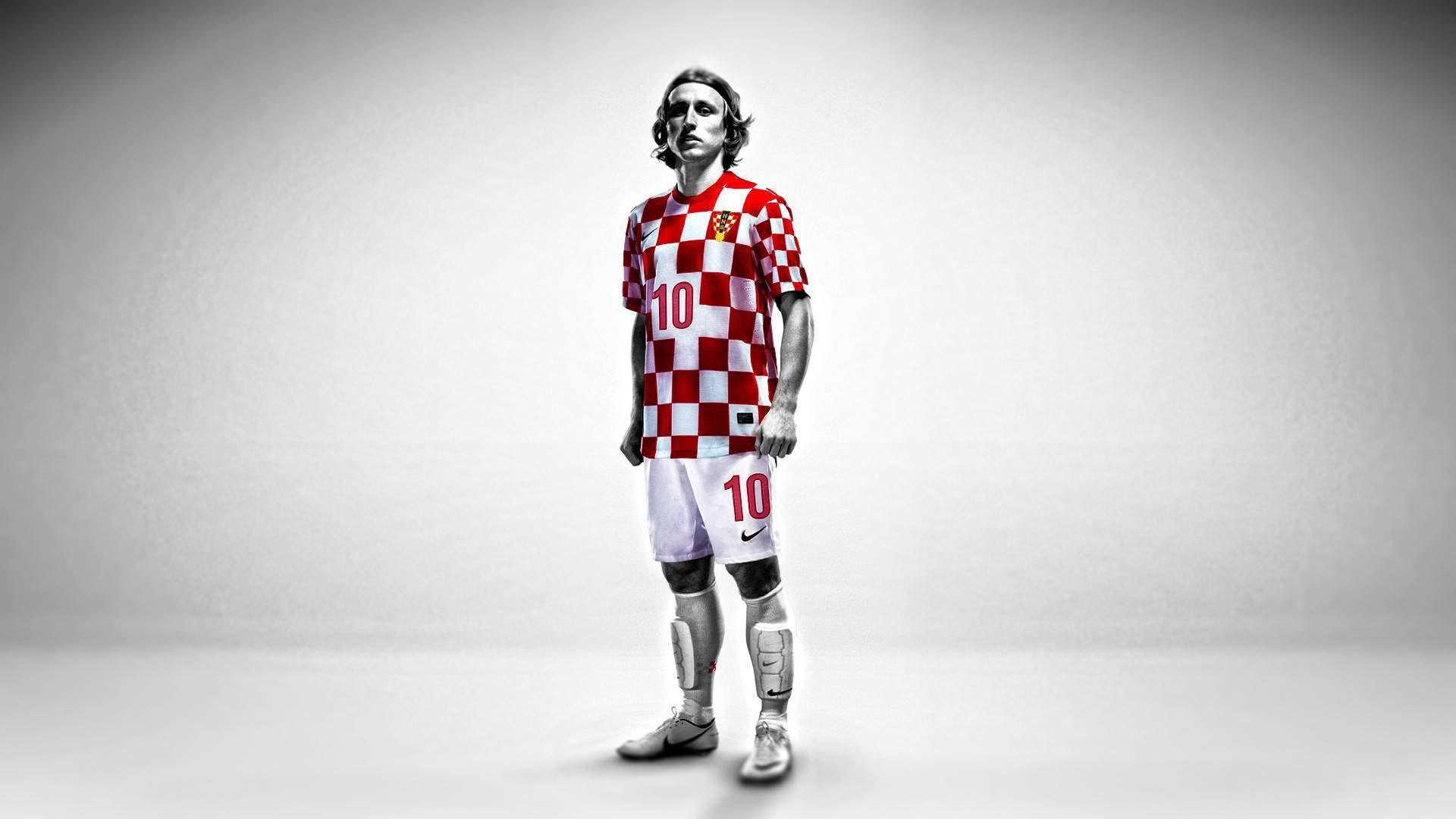 Croatia 桌布 壁紙 — 一名身穿紅白格子球衣、背號10的足球員，自信地站在純灰色攝影棚背景前。