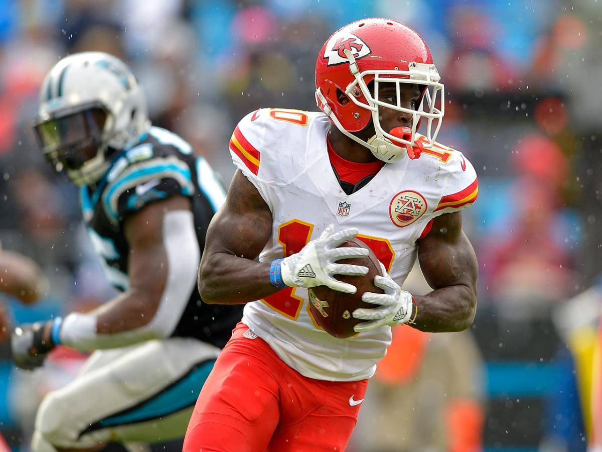 Tyreek Hill 桌布 壁紙 — 一名身穿紅白球衣的堪薩斯城酋長美式足球員在雨中球場帶球奔跑，卡羅萊納黑豹隊的防守球員在追趕他。