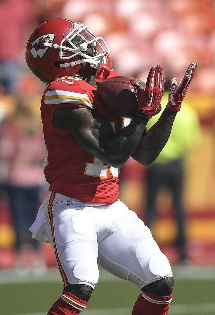Tyreek Hill 桌布 壁紙 — 一名身穿紅白球衣的足球運動員在日間比賽中全神貫注地接住空中的球。