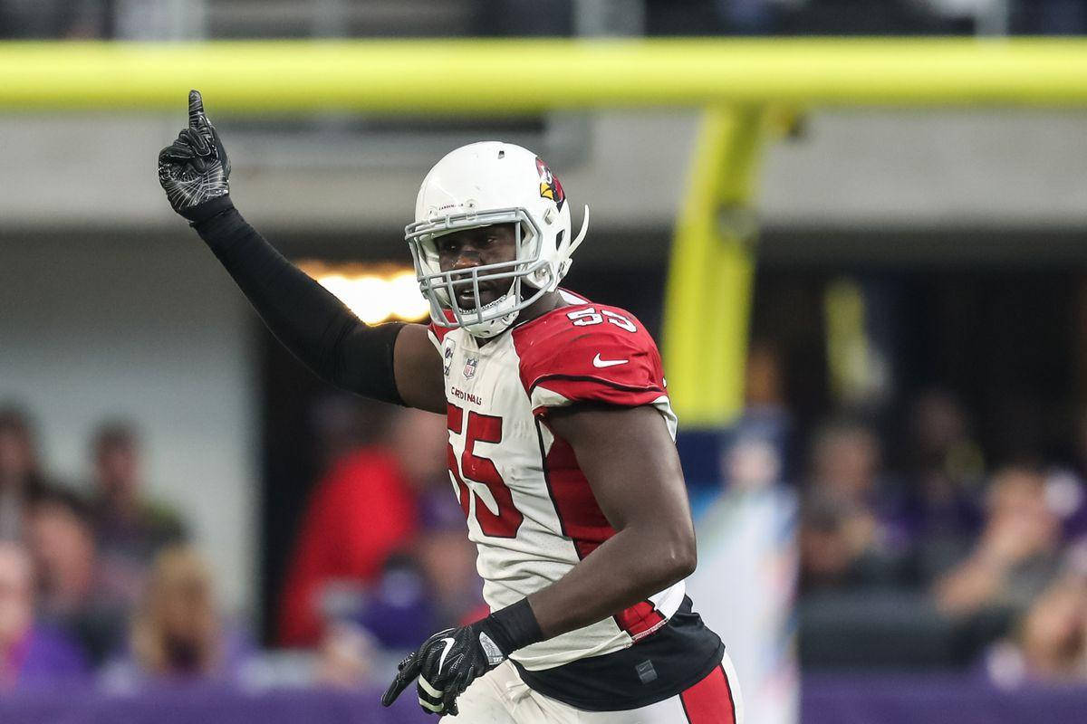 Arizona Cardinals 桌布 壁紙 — 一名身穿紅白球衣的足球運動員在球場燈光下舉起拳頭慶祝。