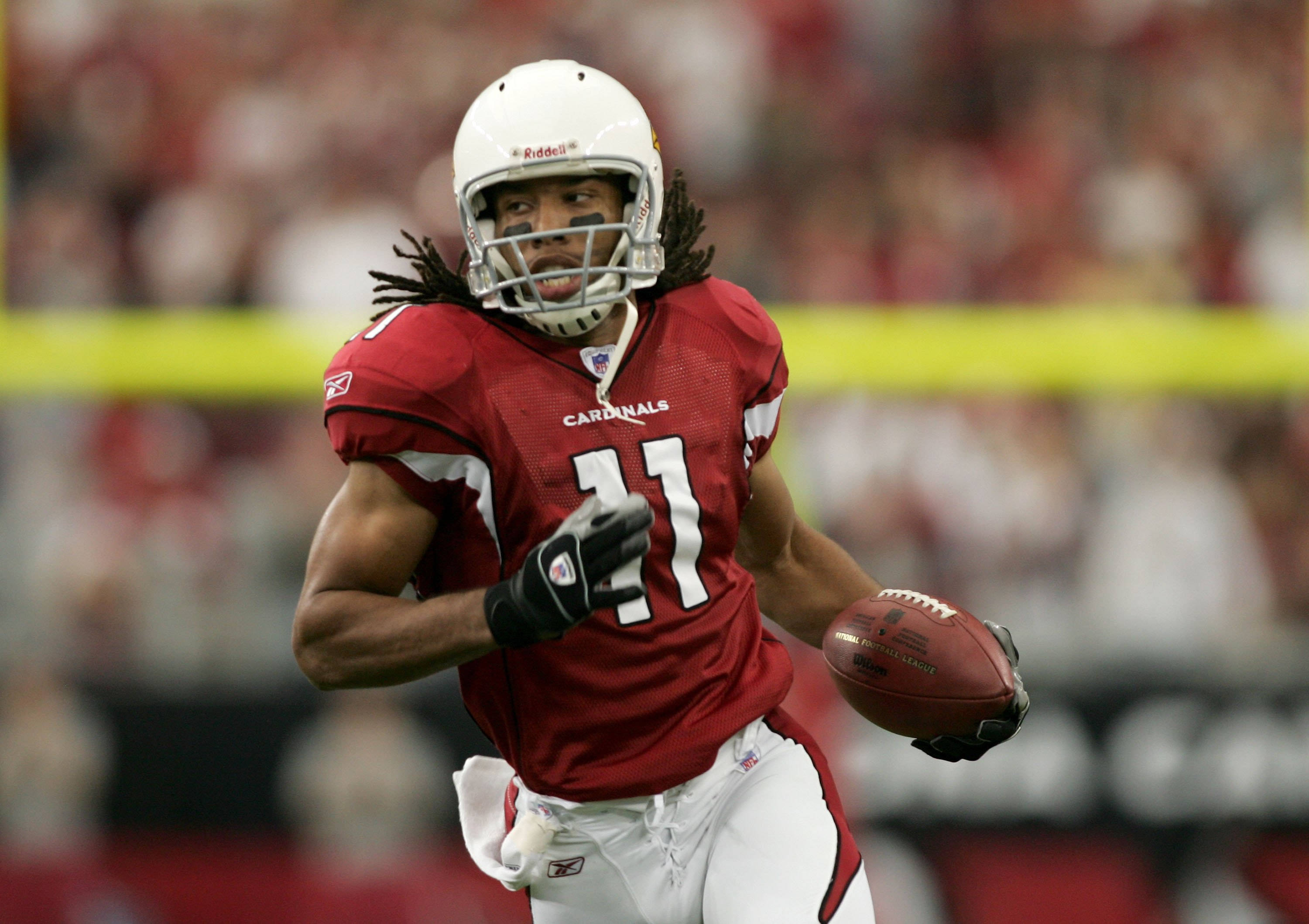 Arizona 桌布 壁紙 — 一名身穿紅色 Cardinals 裝備的足球運動員在體育場燈光下比賽期間持球衝刺。