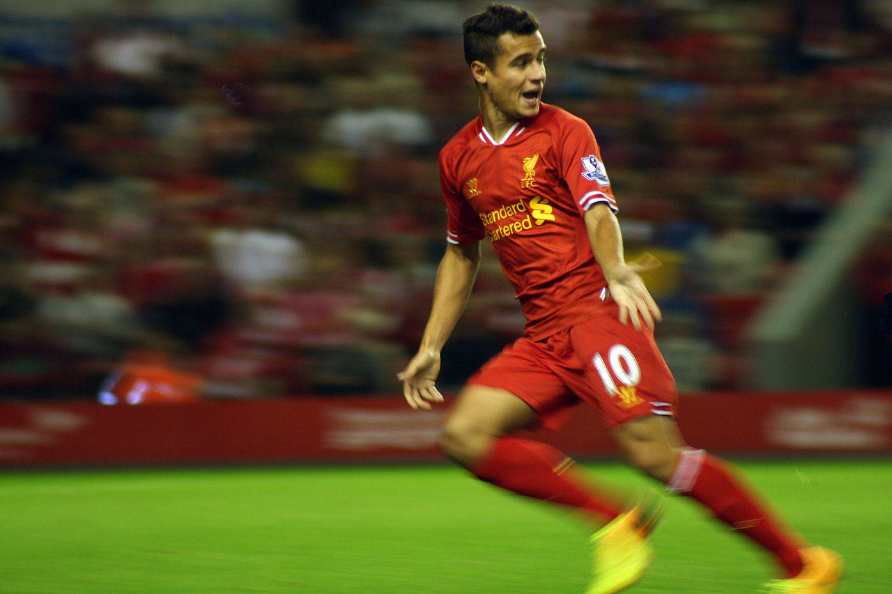Coutinho 桌布 壁紙 — 一名身穿紅色10號球衣的足球運動員在綠色球場上衝刺，背景是模糊的體育場觀眾。