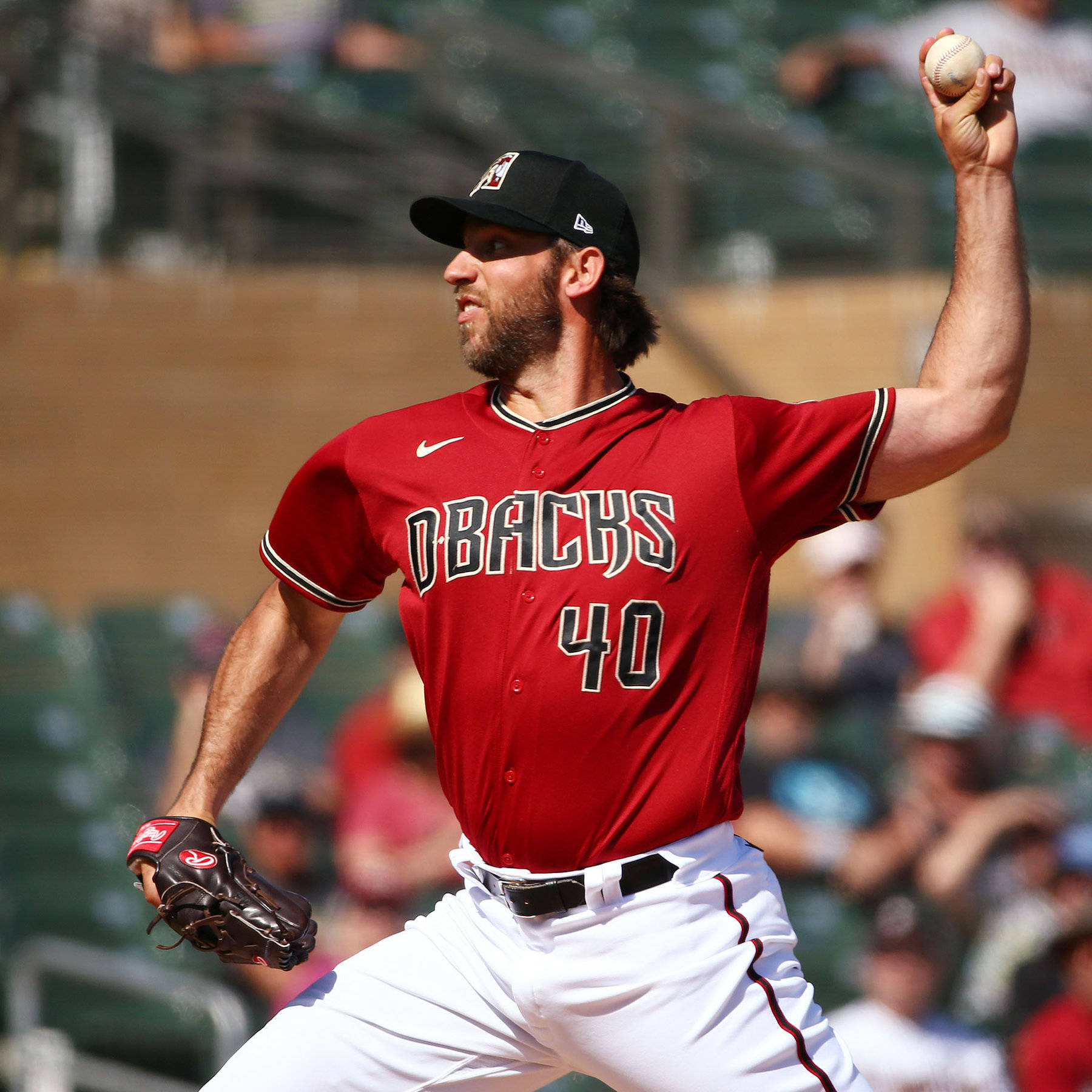 madison bumgarner 桌布 壁紙 — 一名身穿紅色Dbacks球衣的棒球投手在陽光明媚的日間比賽中揮臂投球。