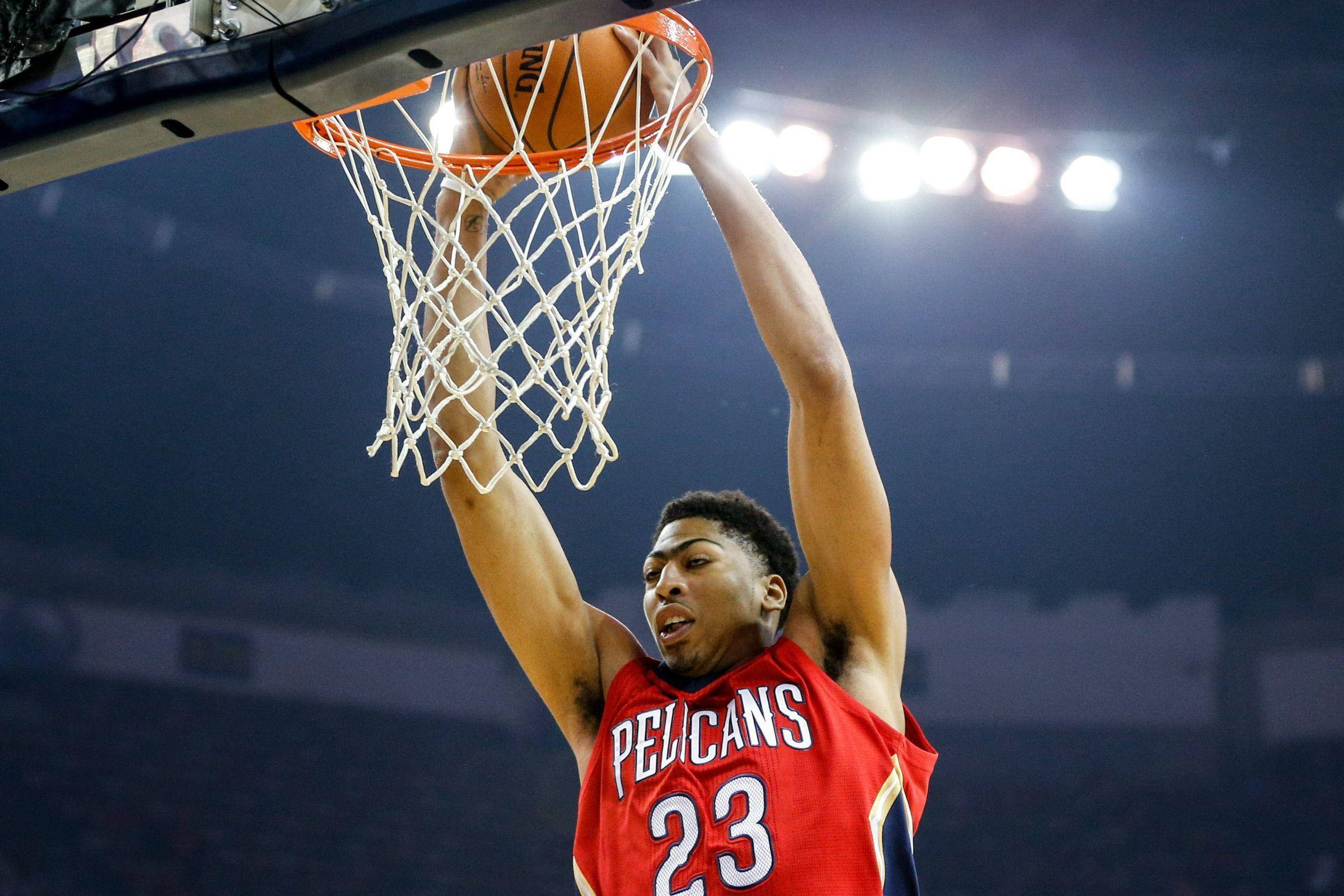 Anthony Davis 桌布 壁紙 — 一名身穿紅色Pelicans球衣的籃球運動員在明亮的場館燈光下，專注地灌籃。