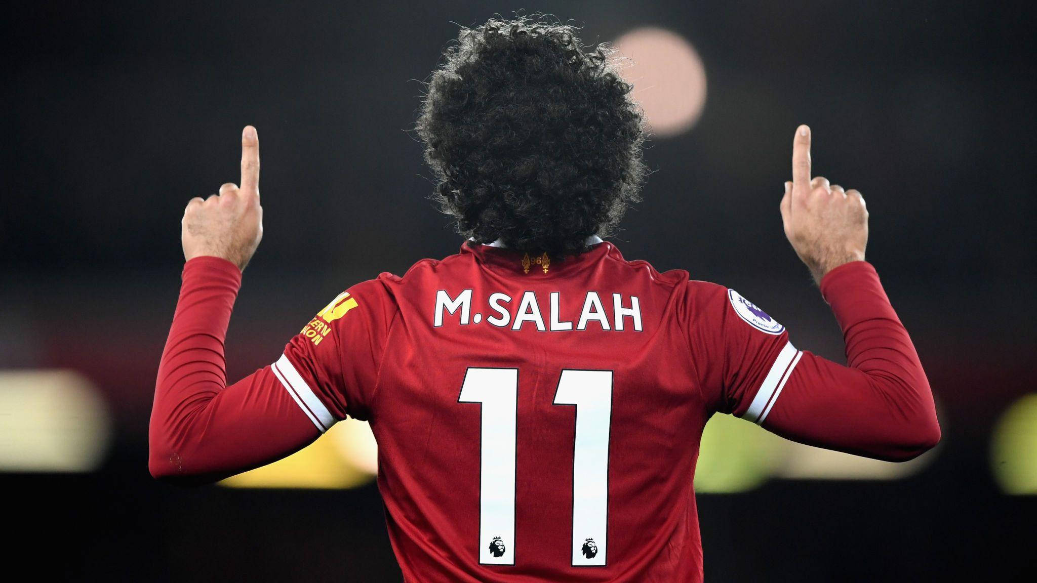 Salah 桌布 壁紙 — 一名身穿紅色利物浦球衣、背後印有名字和11號的足球員，舉起雙食指向上慶祝。