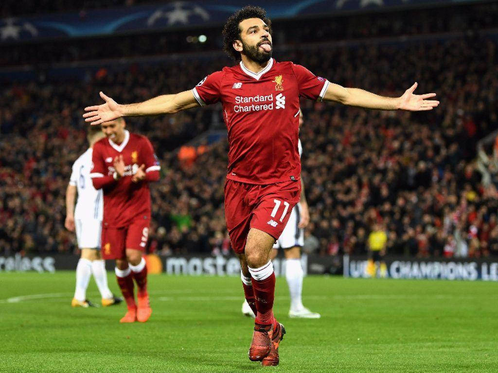 Salah 桌布 壁紙 — 一名身穿紅色利物浦球衣的足球員在明亮的燈光下於球場上張開雙臂勝利慶祝。