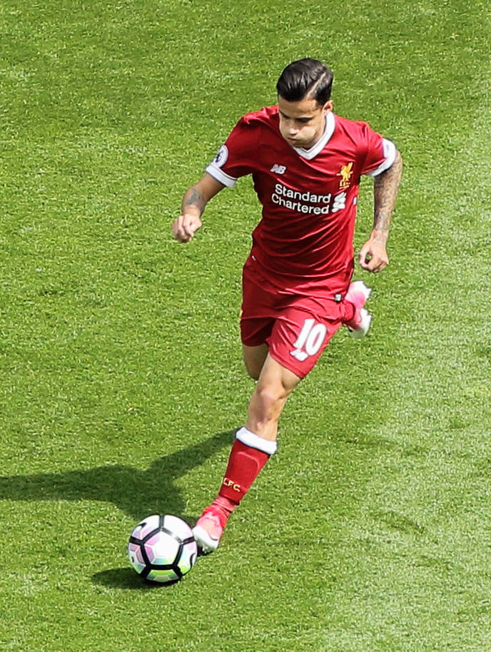 Coutinho 桌布 壁紙 — 一名身穿紅色利物浦球衣的足球員在陽光明媚的綠色球場上運球，球色彩繽紛。