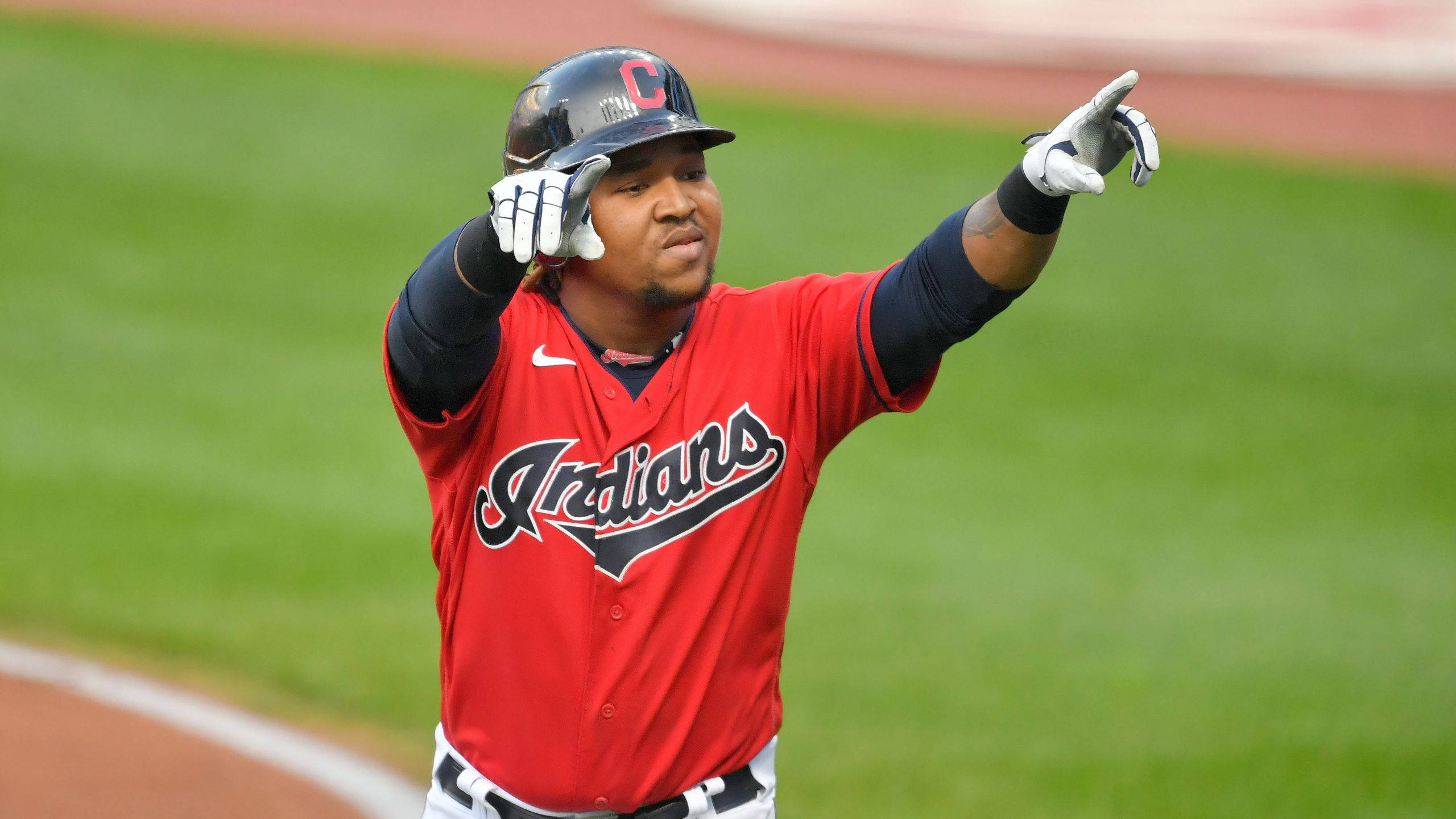 Jose Ramirez 桌布 壁紙 — 一名身穿紅色印第安人球衣的棒球運動員在綠色球場上高舉雙臂慶祝。