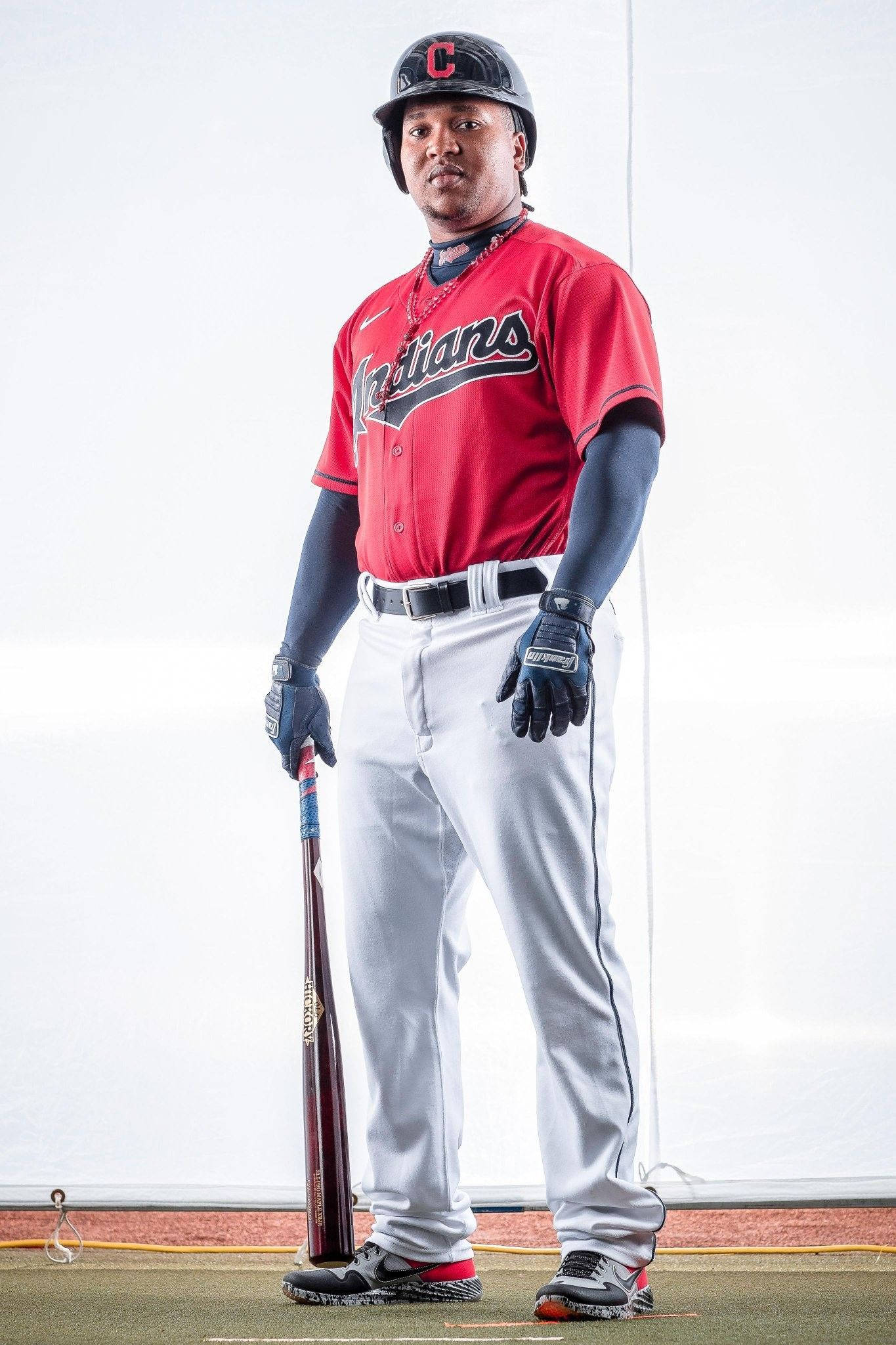 Jose Ramirez 桌布 壁紙 — 一名身穿紅色印第安人球衣的棒球選手，在純白背景前擺好姿勢，手持球棒。