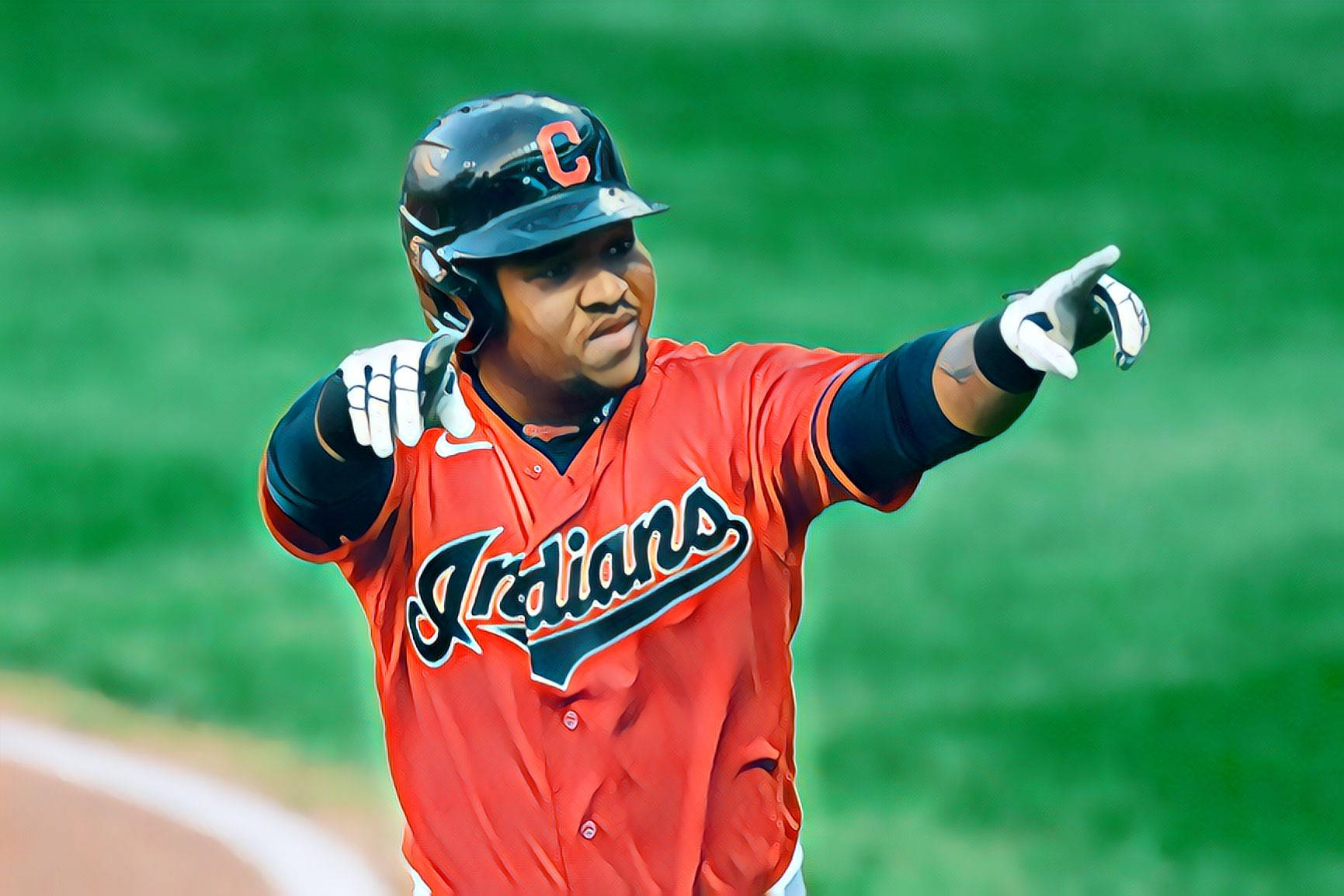 Jose Ramirez 桌布 壁紙 — 一名身穿紅色印第安人隊球衣的棒球運動員，在模糊的綠色場地上用手指指向慶祝。