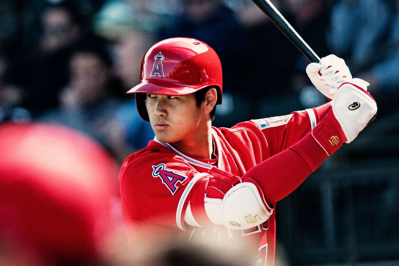 MLB 桌布 壁紙 — 一名身穿紅色天使隊球衣的棒球選手在日間比賽中專注地揮棒。