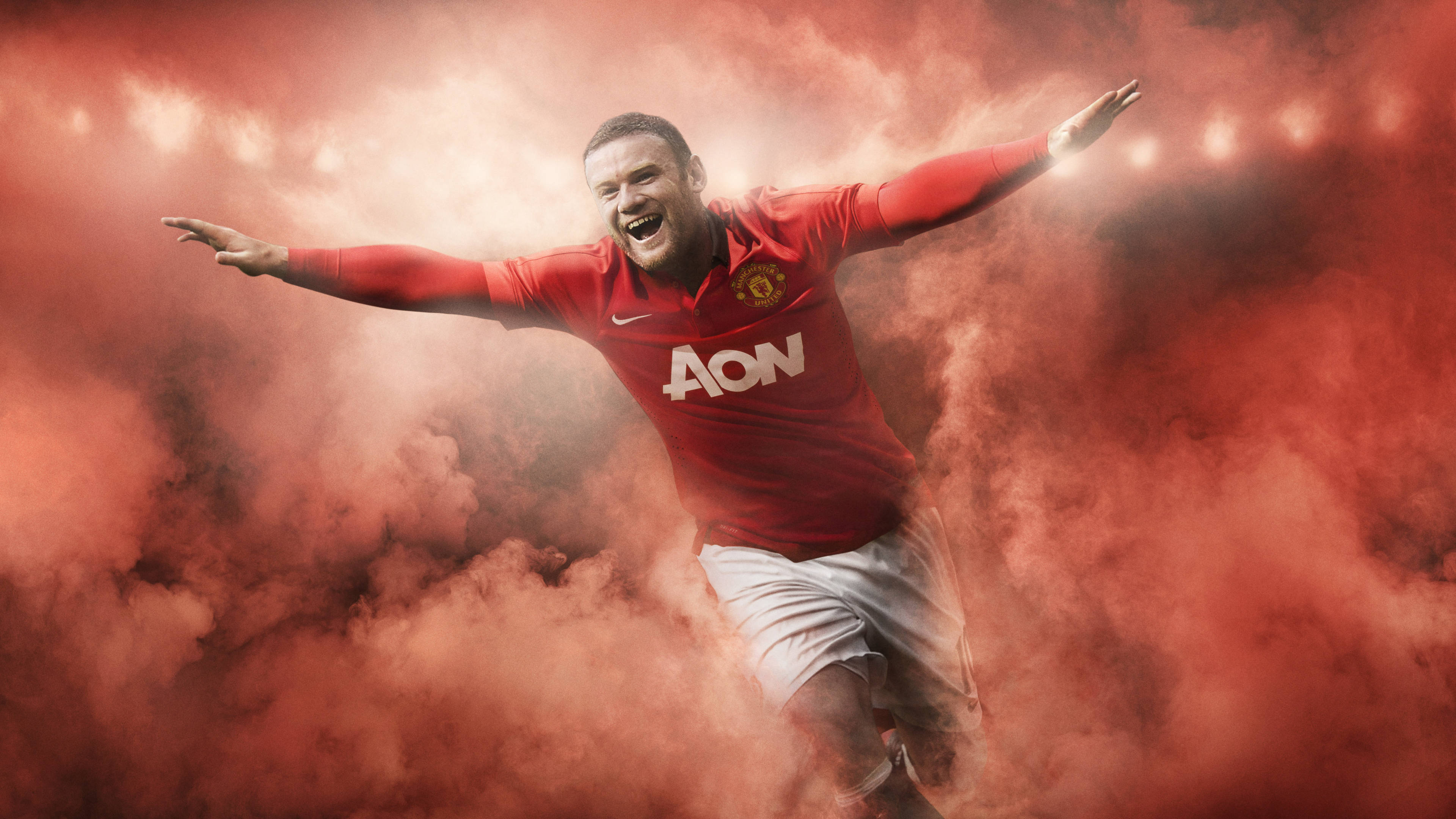 Rooney 桌布 壁紙 — 一名身穿紅色曼聯球衣的足球員在旋轉的紅煙中張開雙臂勝利慶祝。