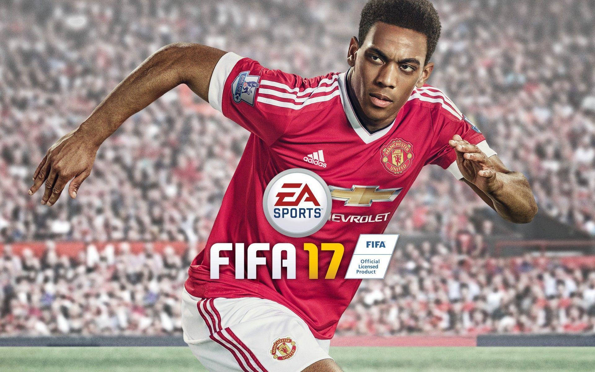 Anthony Martial 桌布 壁紙 — 一名身穿紅色曼聯球衣的足球員在球場上疾馳，背景是模糊的人群。