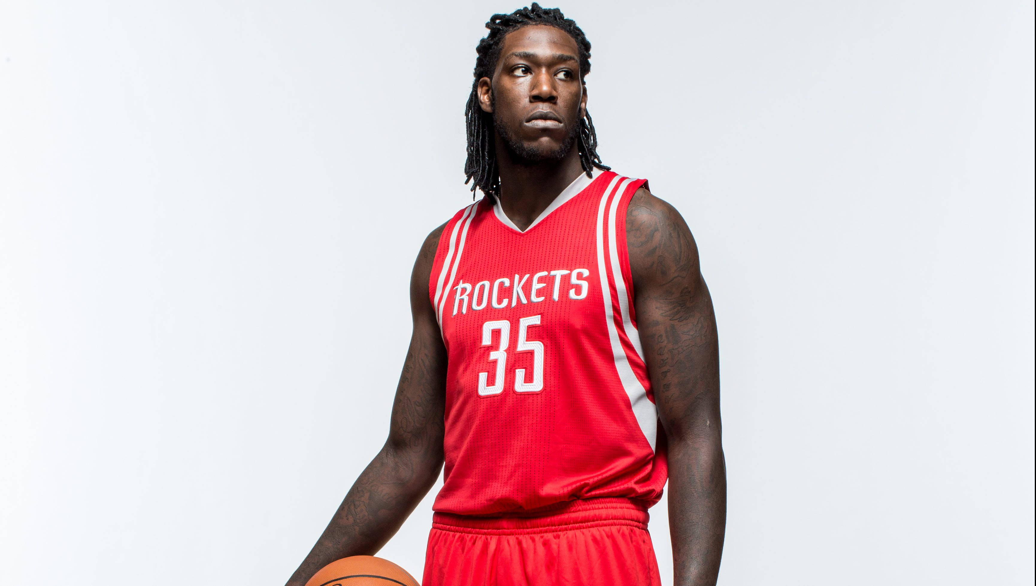 montrezl harrell 桌布 壁紙 — 一名身穿紅色火箭隊球衣的籃球運動員，在純白色背景前持球。