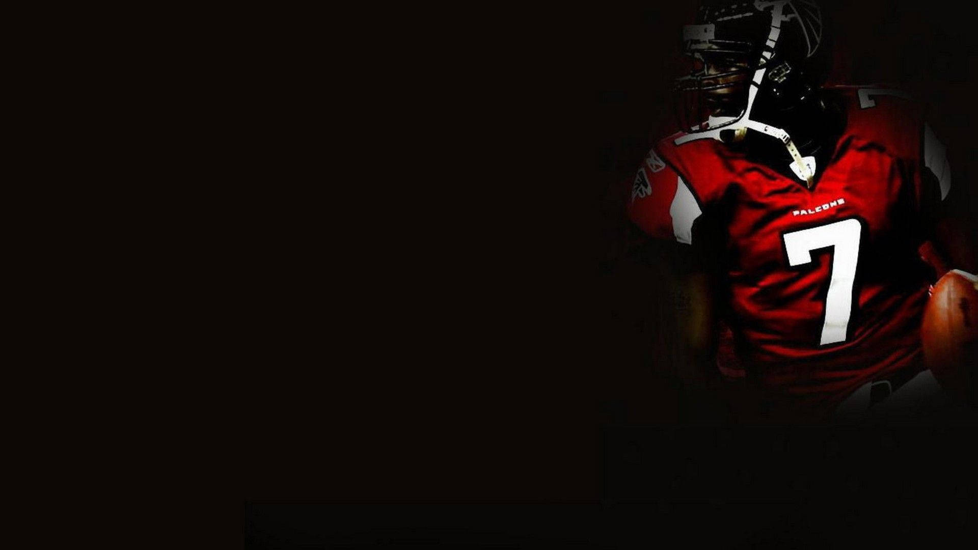 酷炫 NFL 桌布 壁紙 — 一名身穿紅色獵鷹隊球衣、號碼7的足球員站在陰影中，手持一個球。