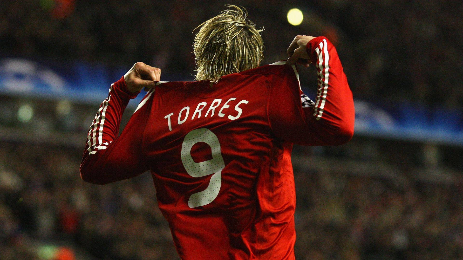 Torres 桌布 壁紙 — 一名身穿紅色球衣、印有名字 TORRES 和號碼 9 的足球運動員在球場燈光下將球衣拉過頭頂慶祝。