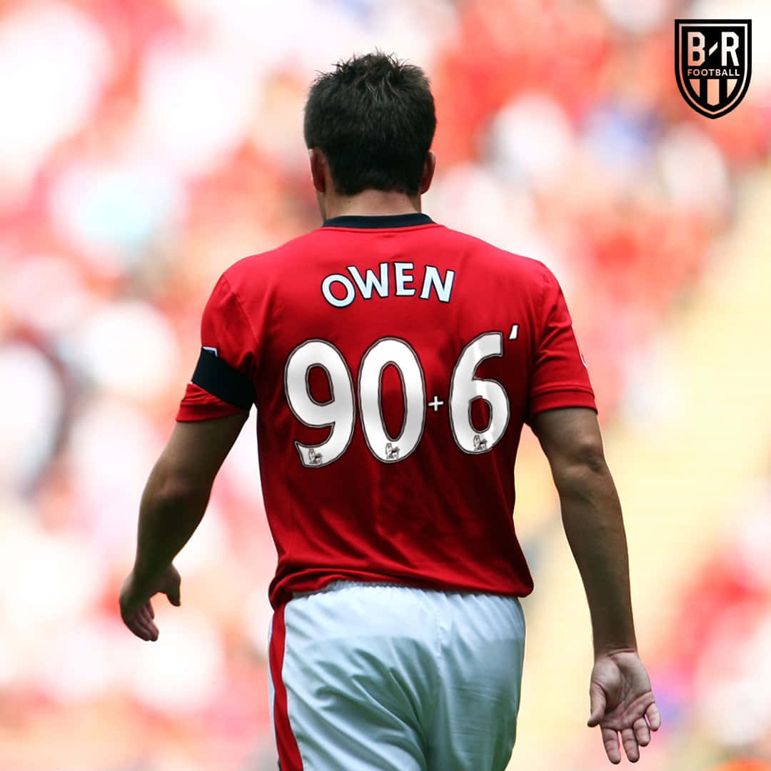 曼聯 桌布 壁紙 — 一名身穿紅色球衣、背後印有「OWEN」和「90+6」的足球員在陽光明媚的球場上背對鏡頭走開。