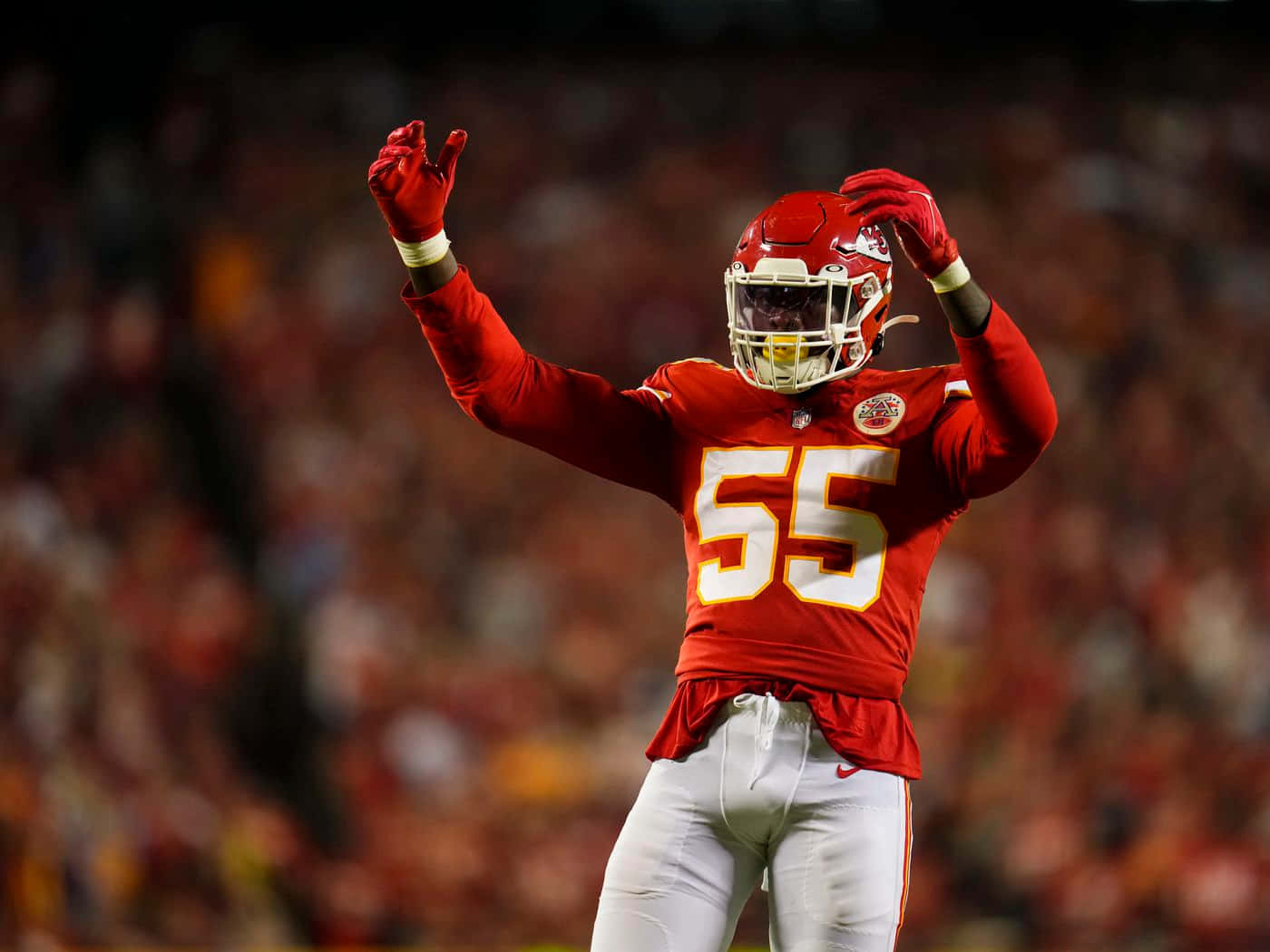 Frank Clark 桌布 壁紙 — 一名身穿紅色球衣、號碼55的足球員在球場燈光下高舉雙手慶祝，背景是模糊的人群。
