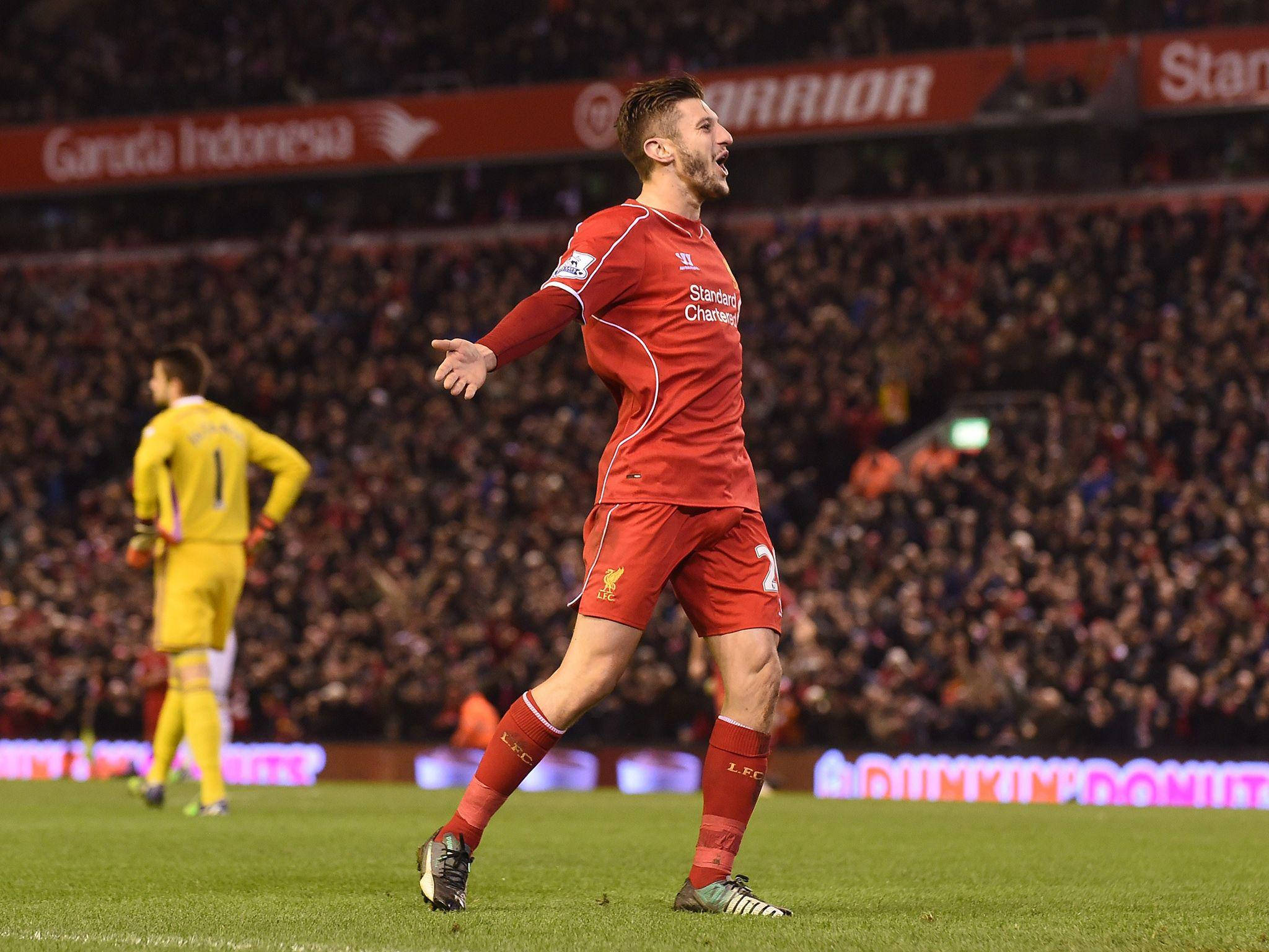 Liverpool Fc 桌布 壁紙 — 一名身穿紅色球衣的利物浦足球員在燈光璀璨的球場上熱情慶祝，背後是模糊的人群。