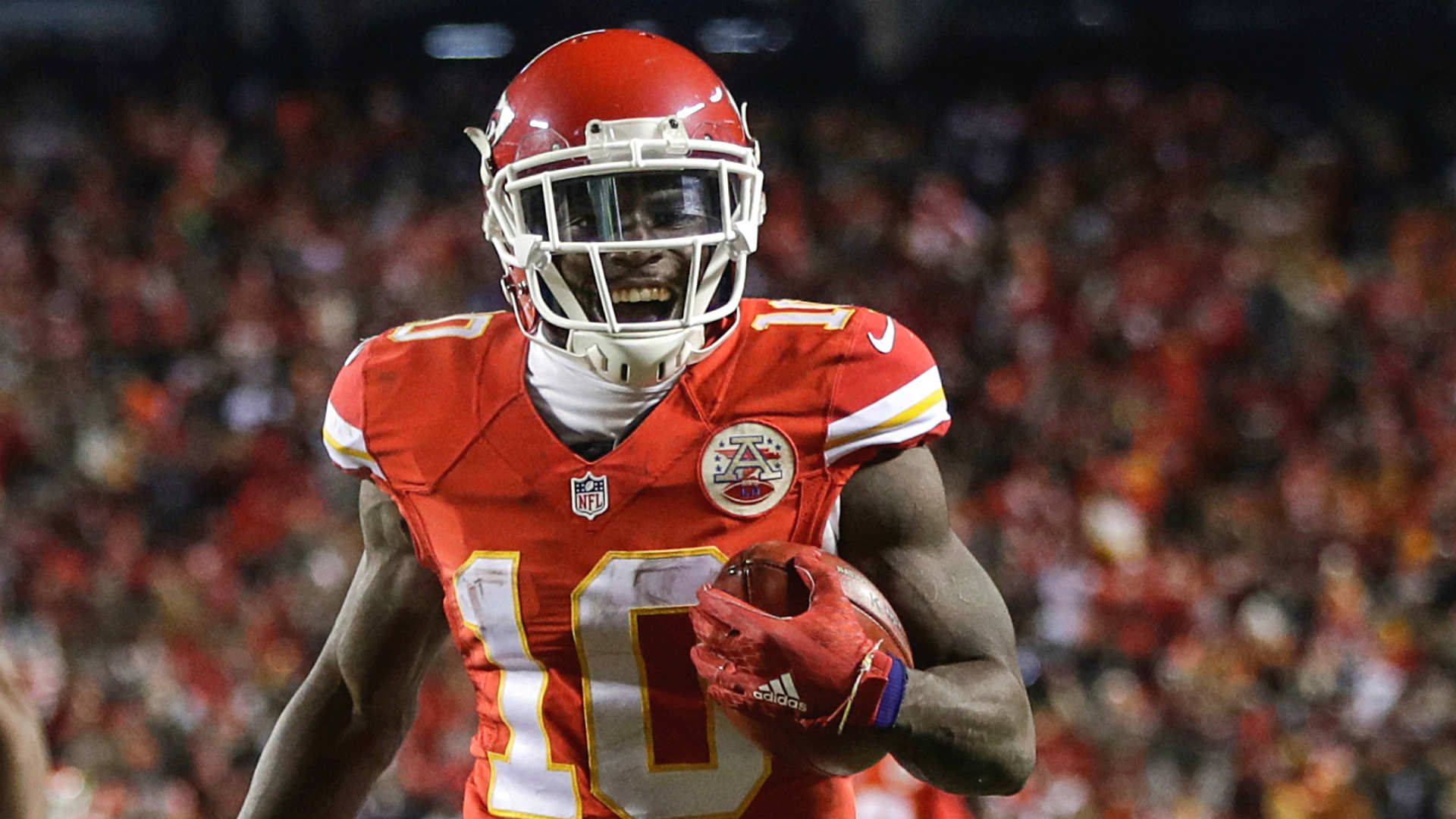 Tyreek Hill 桌布 壁紙 — 一名身穿紅色球衣的堪薩斯城酋長隊美式足球員在球場燈光下帶球奔跑。