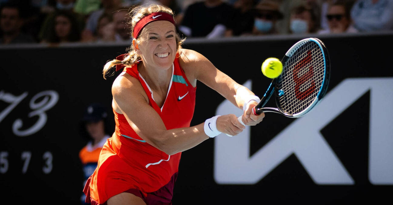 Athletic 桌布 壁紙 — 一名身穿紅色球衣的女網球選手在比賽中揮拍擊打黃色網球，神情專注。