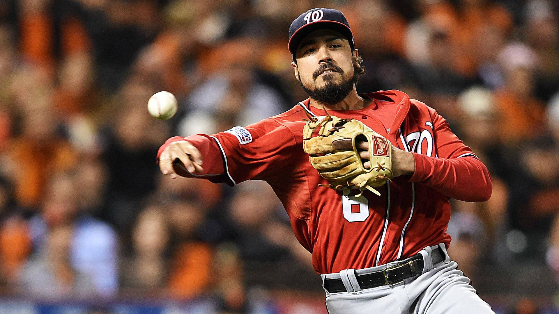 anthony rendon 桌布 壁紙 — 一名身穿紅色球衣的棒球投手正在投球，身後有模糊的橙色人群。