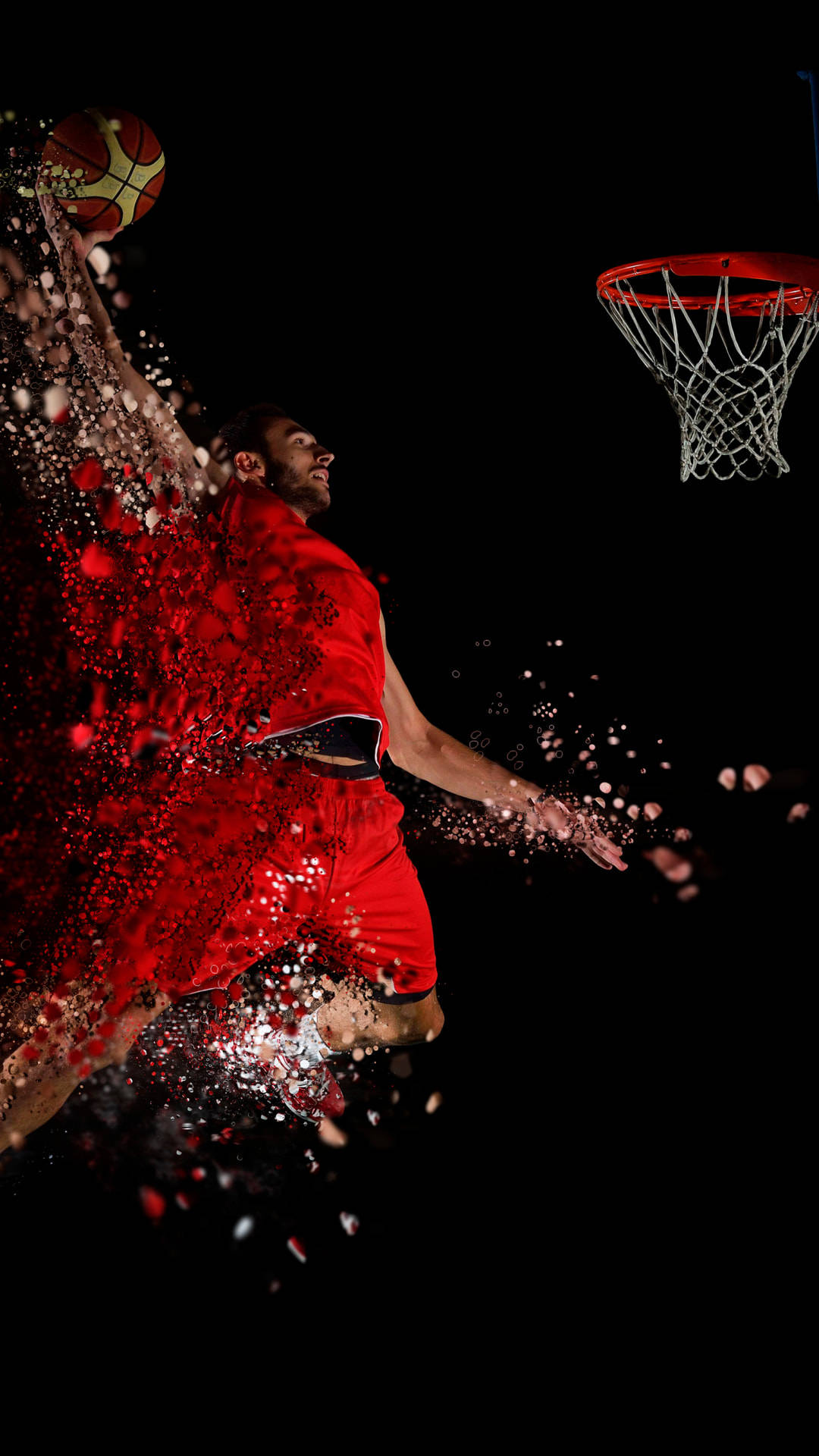 cool basketball iPhone 桌布 壁紙 — 一名身穿紅色球衣的籃球運動員在半空中灌籃，紅色粒子從他的身體爆炸開來，背景為黑色。