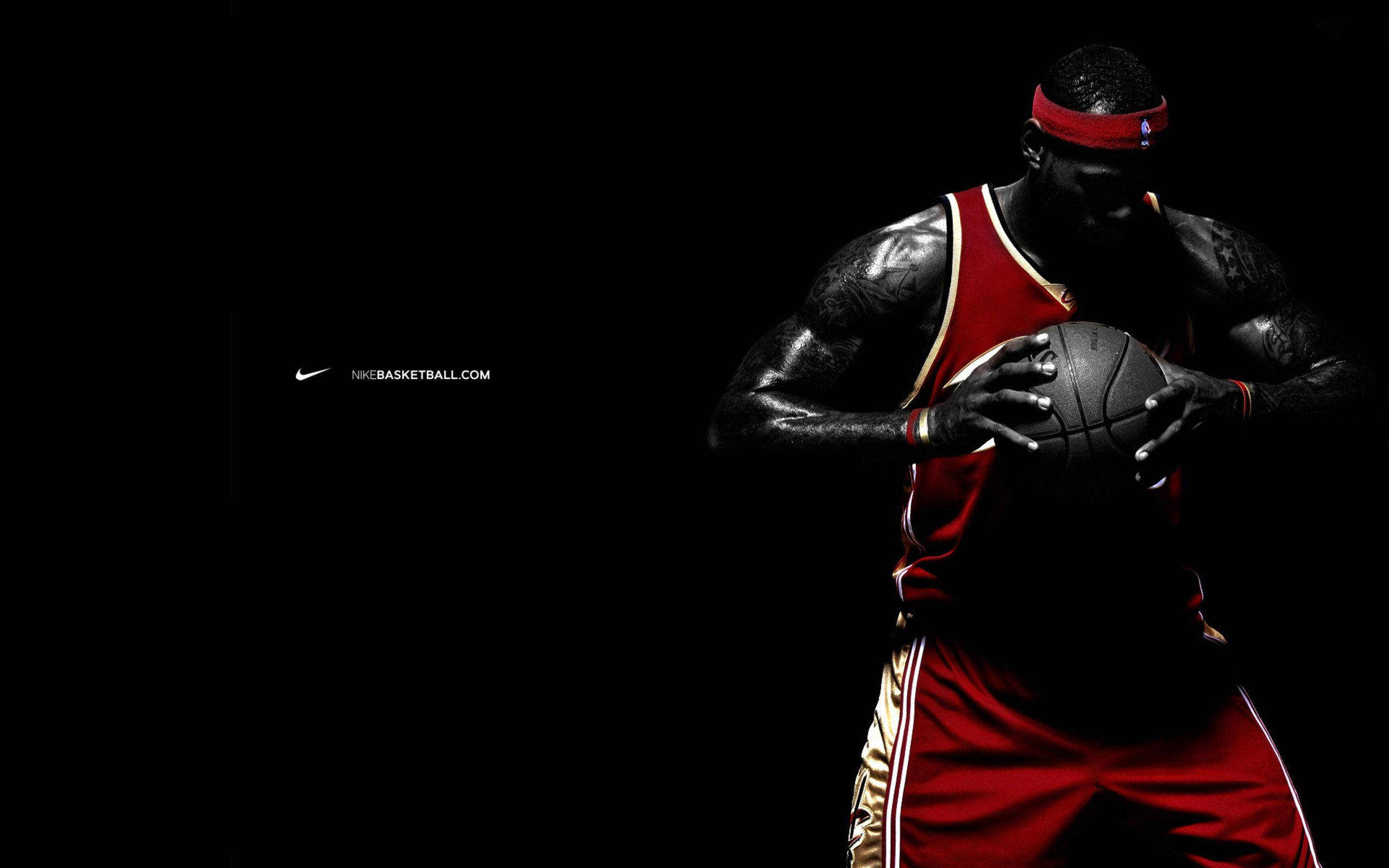 NBA 桌布 壁紙 — 一名身穿紅色球衣的籃球運動員在戲劇性燈光的黑色背景下抓住一個球。
