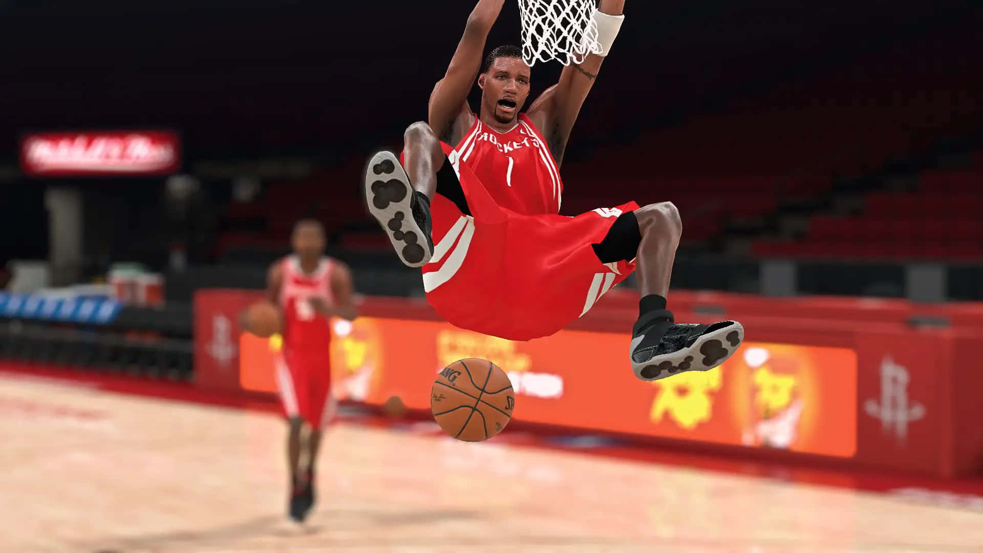 Tracy Mcgrady 桌布 壁紙 — 一名身穿紅色球衣的籃球運動員在燈光璀璨的場館中，全神貫注地於空中灌籃。