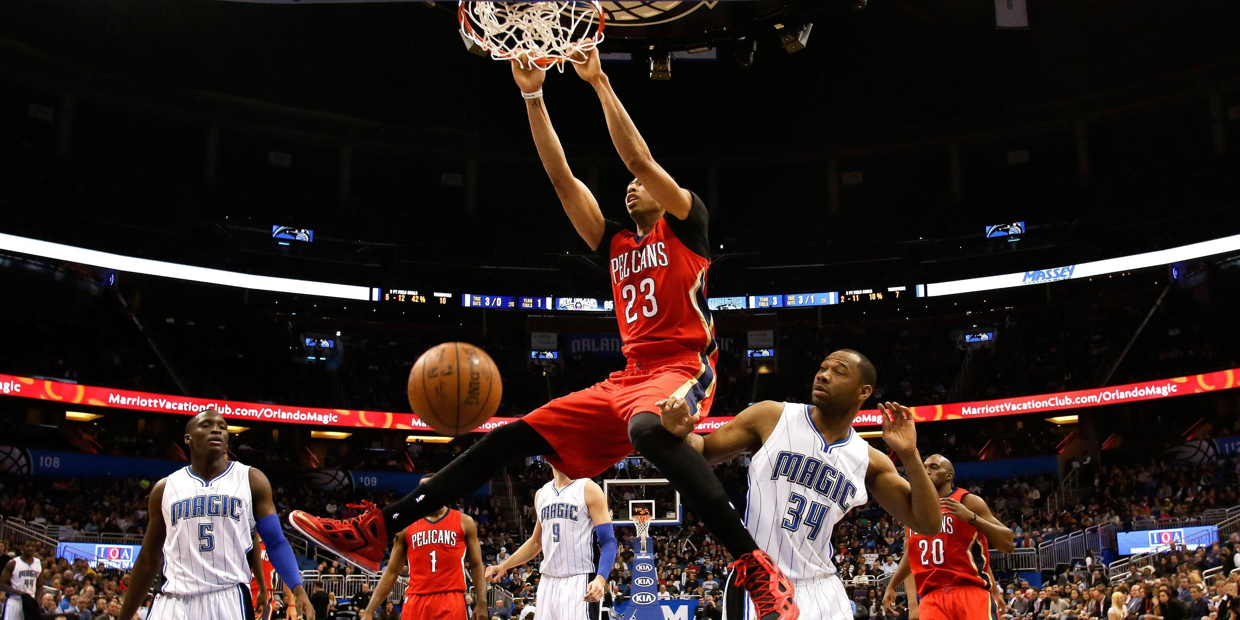 Anthony Davis 桌布 壁紙 — 一名身穿紅色球衣的籃球運動員高高躍起準備灌籃，而身穿白色球衣的防守球員在場館燈光下試圖阻擋他。