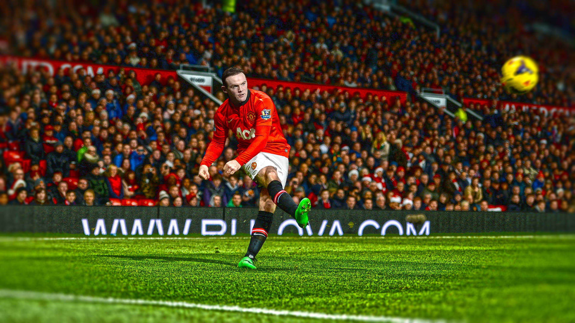 Rooney 桌布 壁紙 — 一名身穿紅色球衣的足球員在充滿活力的綠色球場上踢著黃色球，面前是座無虛席的體育場觀眾。
