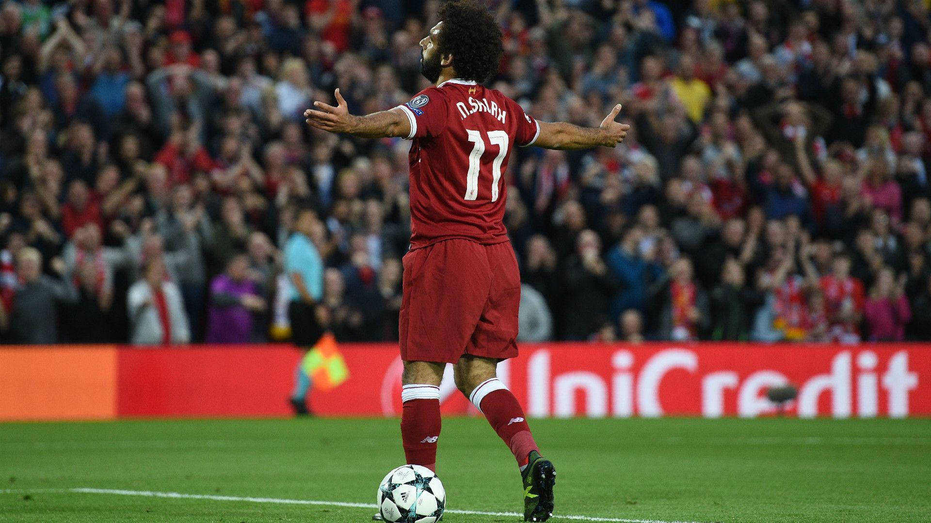 Salah 桌布 壁紙 — 一名身穿紅色球衣的足球員在球場上張開雙臂慶祝，身後有球迷歡呼。