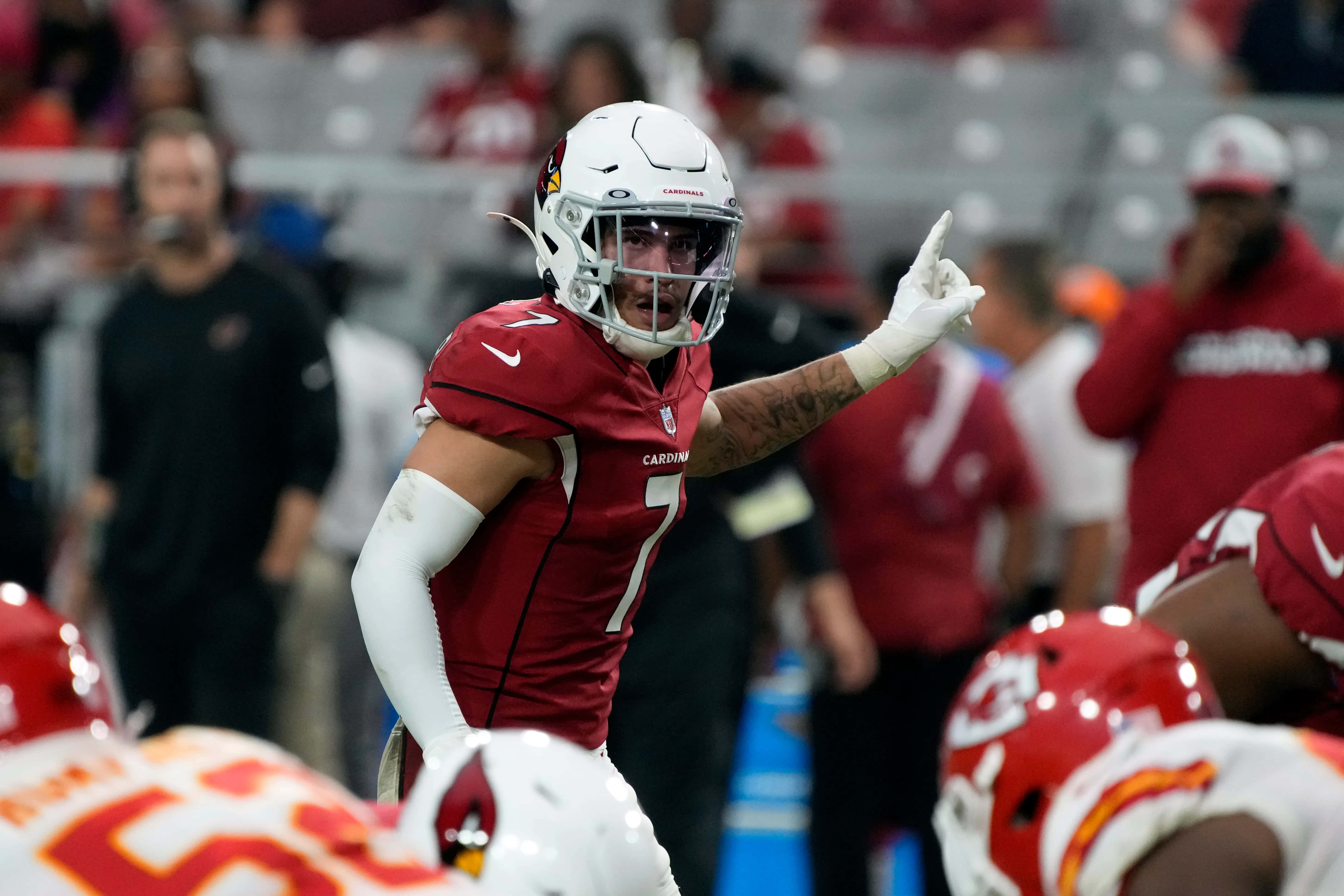 Byron Murphy 桌布 壁紙 — 一名身穿紅色球衣的足球員在球場燈光下比賽時，堅定地指向天空。