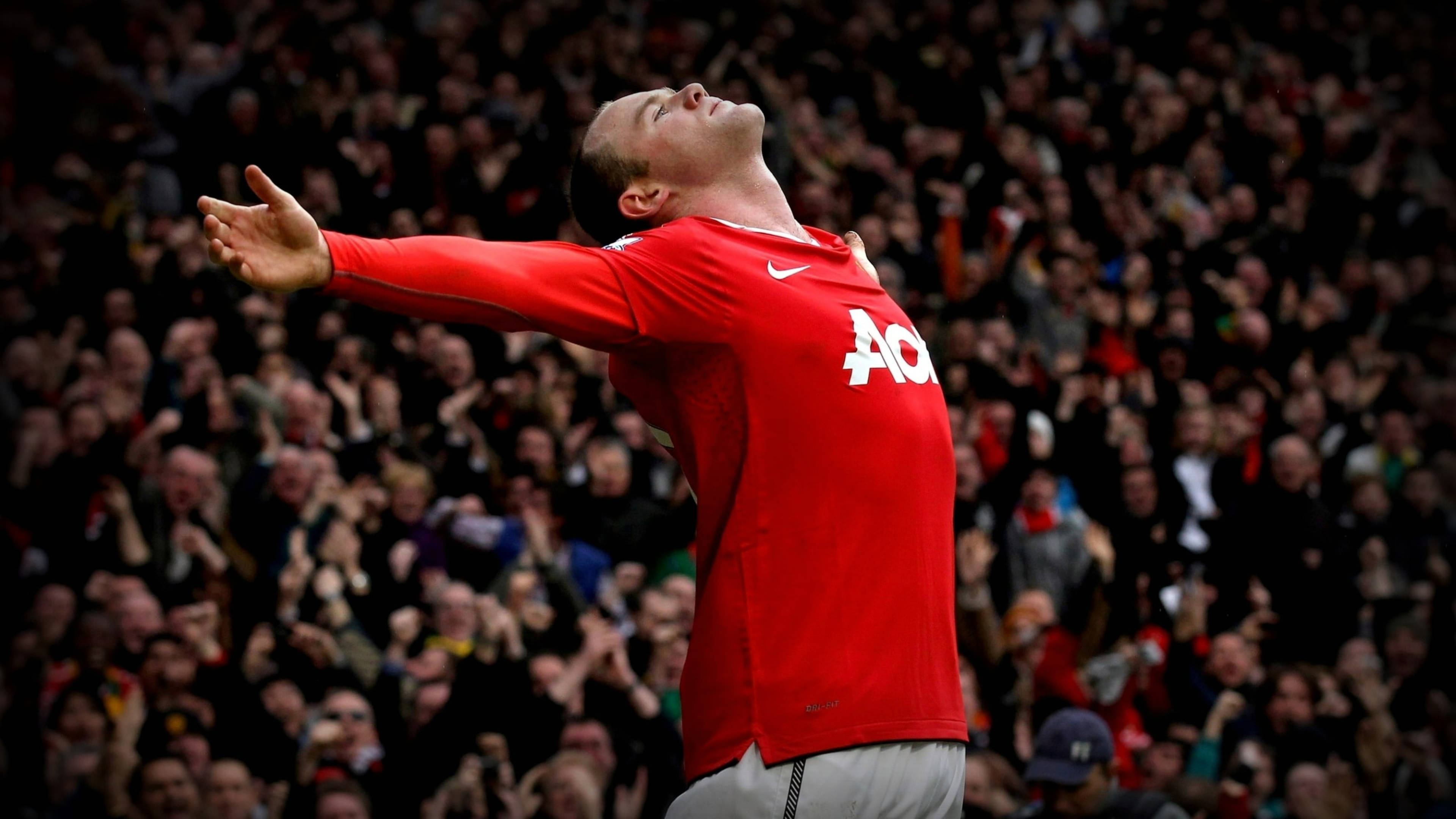Rooney 桌布 壁紙 — 一名身穿紅色球衣的足球員張開雙臂慶祝勝利，身後是震耳欲聾的歡呼人群。