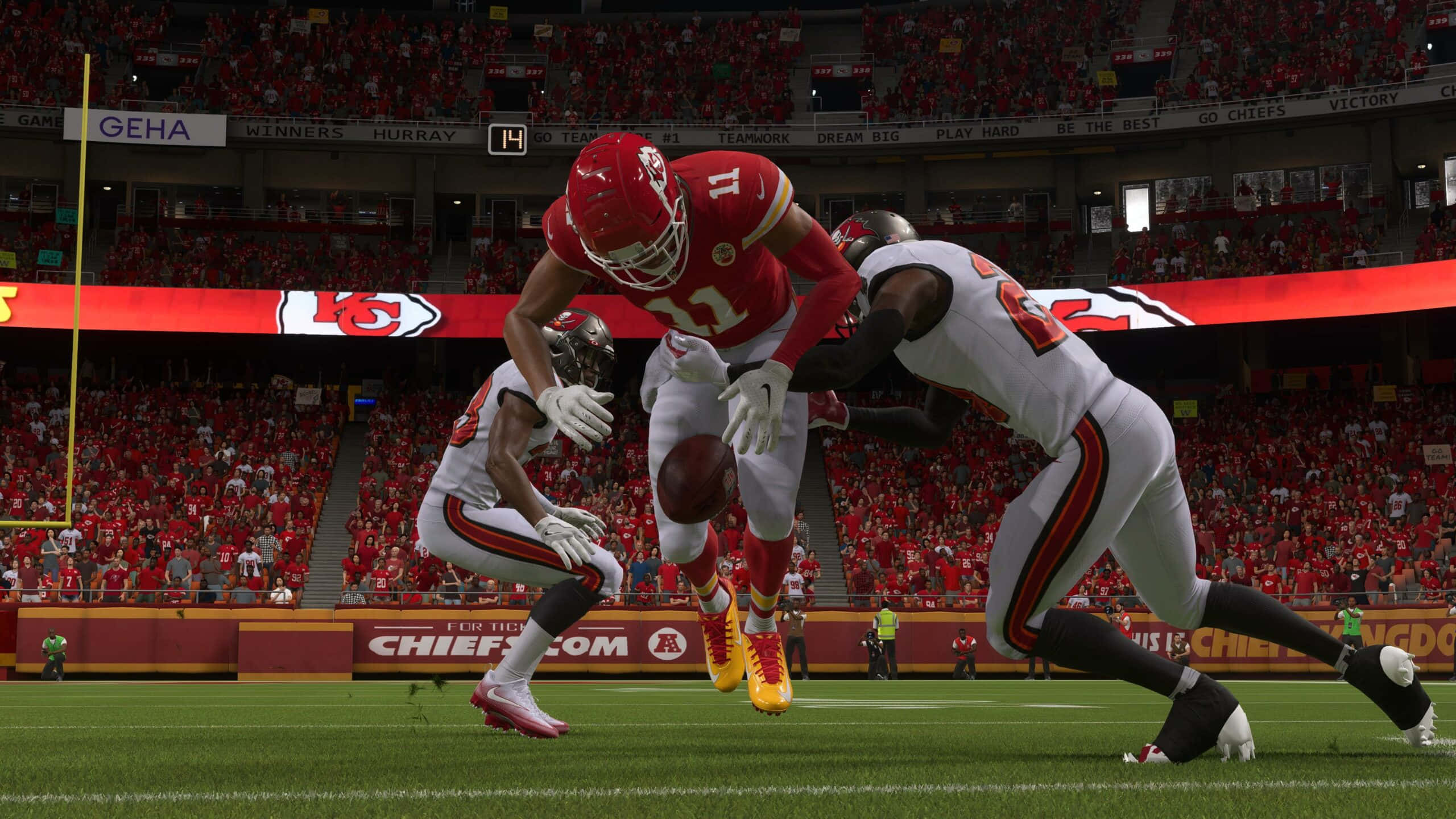 Madden NFL 22 桌布 壁紙 — 一名身穿紅色球衣的足球員跳起接球，白色球衣的防守球員在擠滿觀眾的球場比賽中逼近。