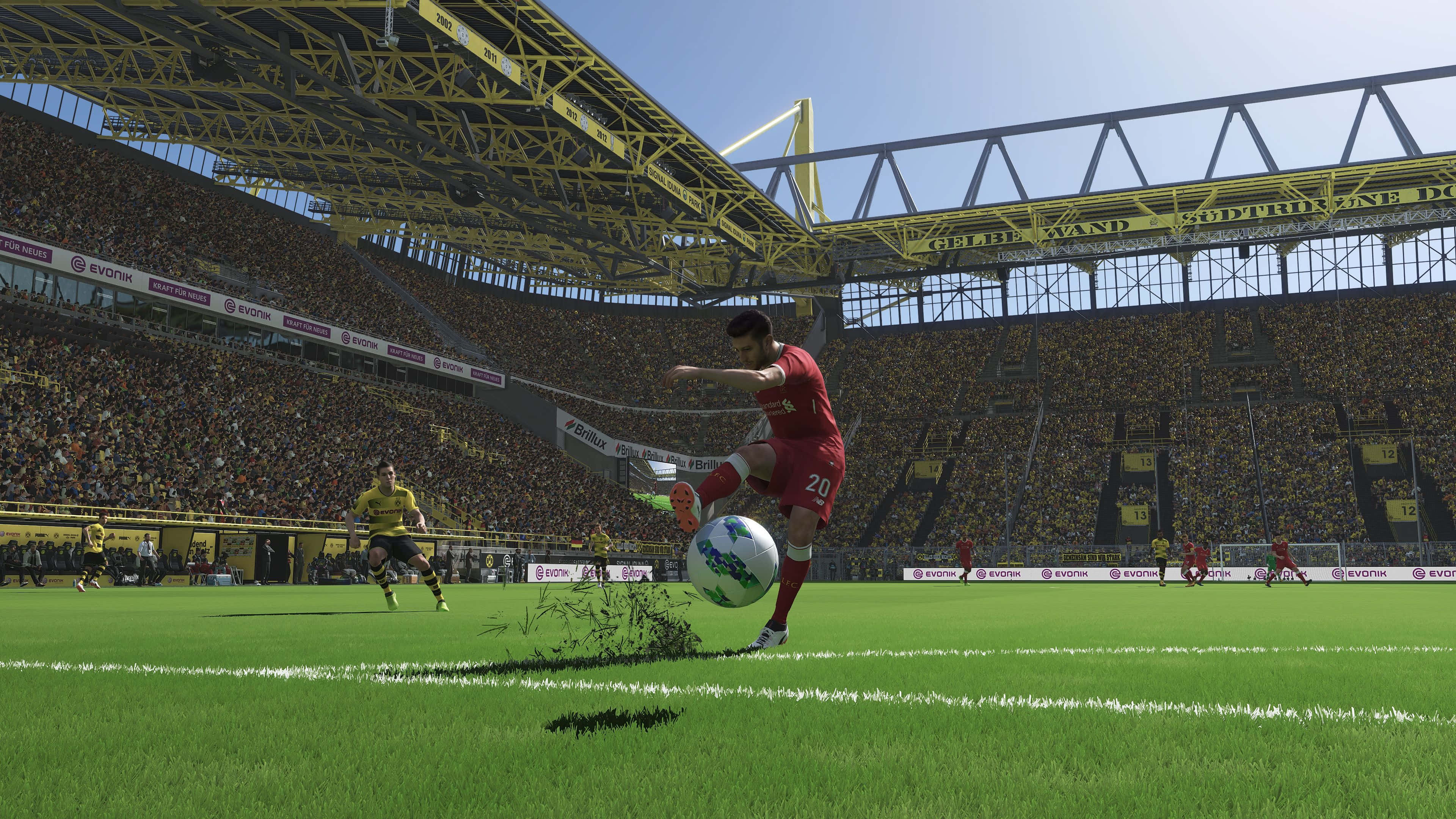 Soccer 4K 桌布 壁紙 — 一名身穿紅色球衣的足球運動員在充滿活力的綠色球場上踢球，上方是明亮的黃色體育場屋頂，周圍有歡呼的球迷。