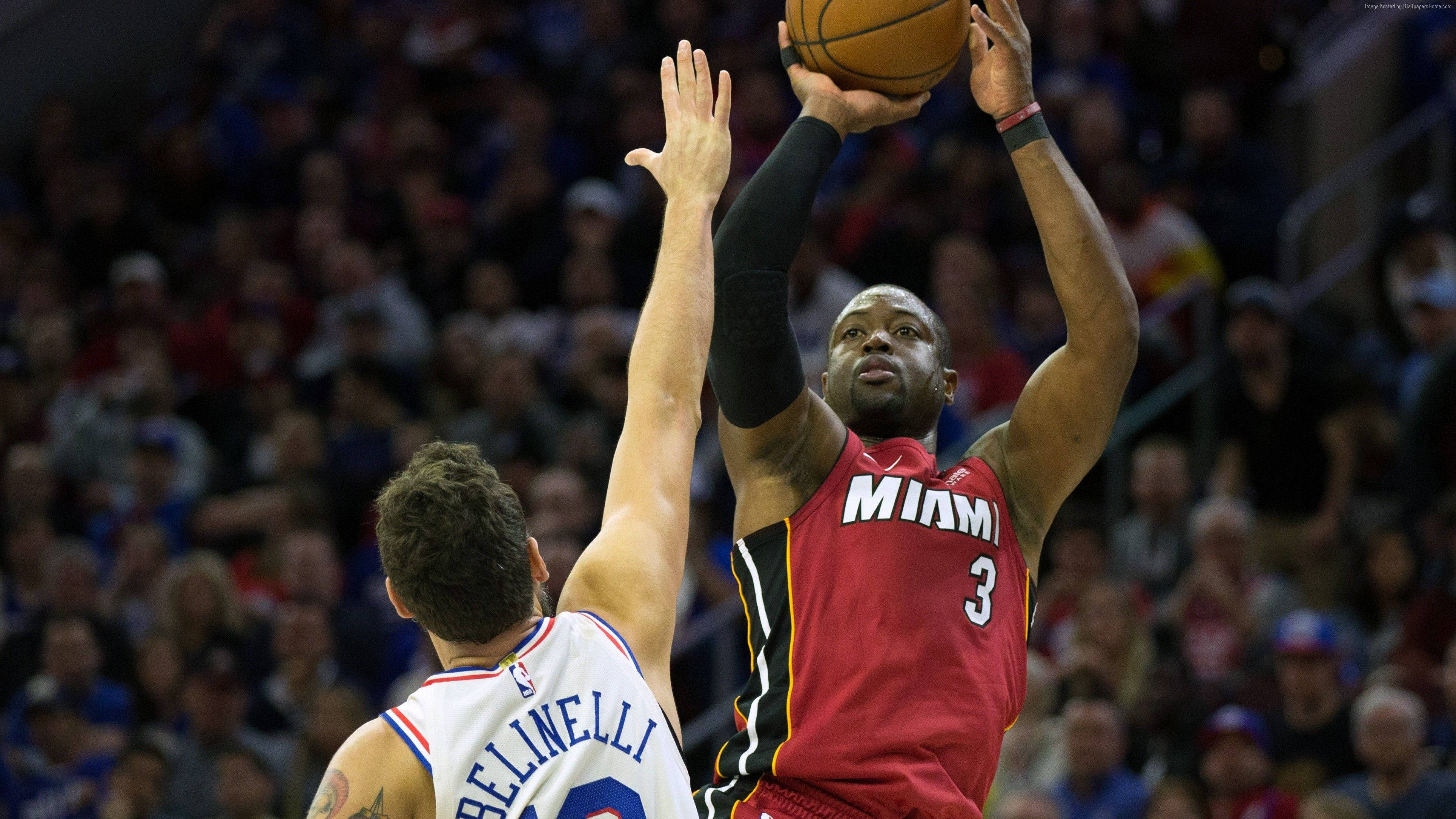 NBA 桌布 壁紙 — 一名身穿紅色球衣的邁阿密熱火球員跳起投籃，而一名白色球衣的防守球員舉起雙臂試圖封阻。