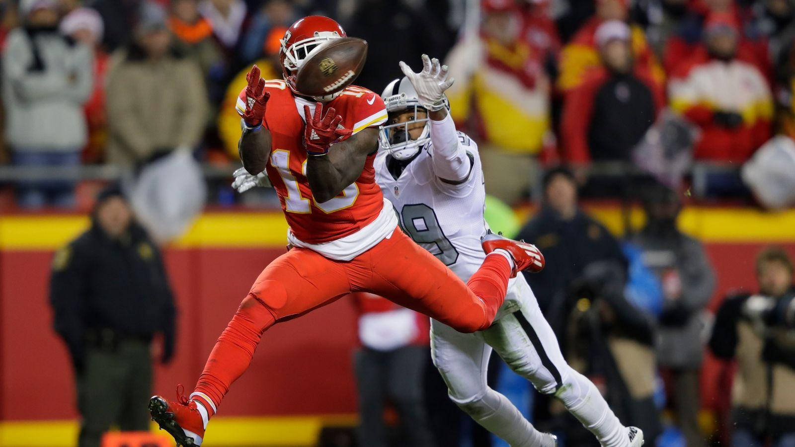 Tyreek Hill 桌布 壁紙 — 一名身穿紅色的堪薩斯城酋長隊球員跳起接住美式足球，而一名身穿白色的達拉斯牛仔隊防守球員試圖攔截。