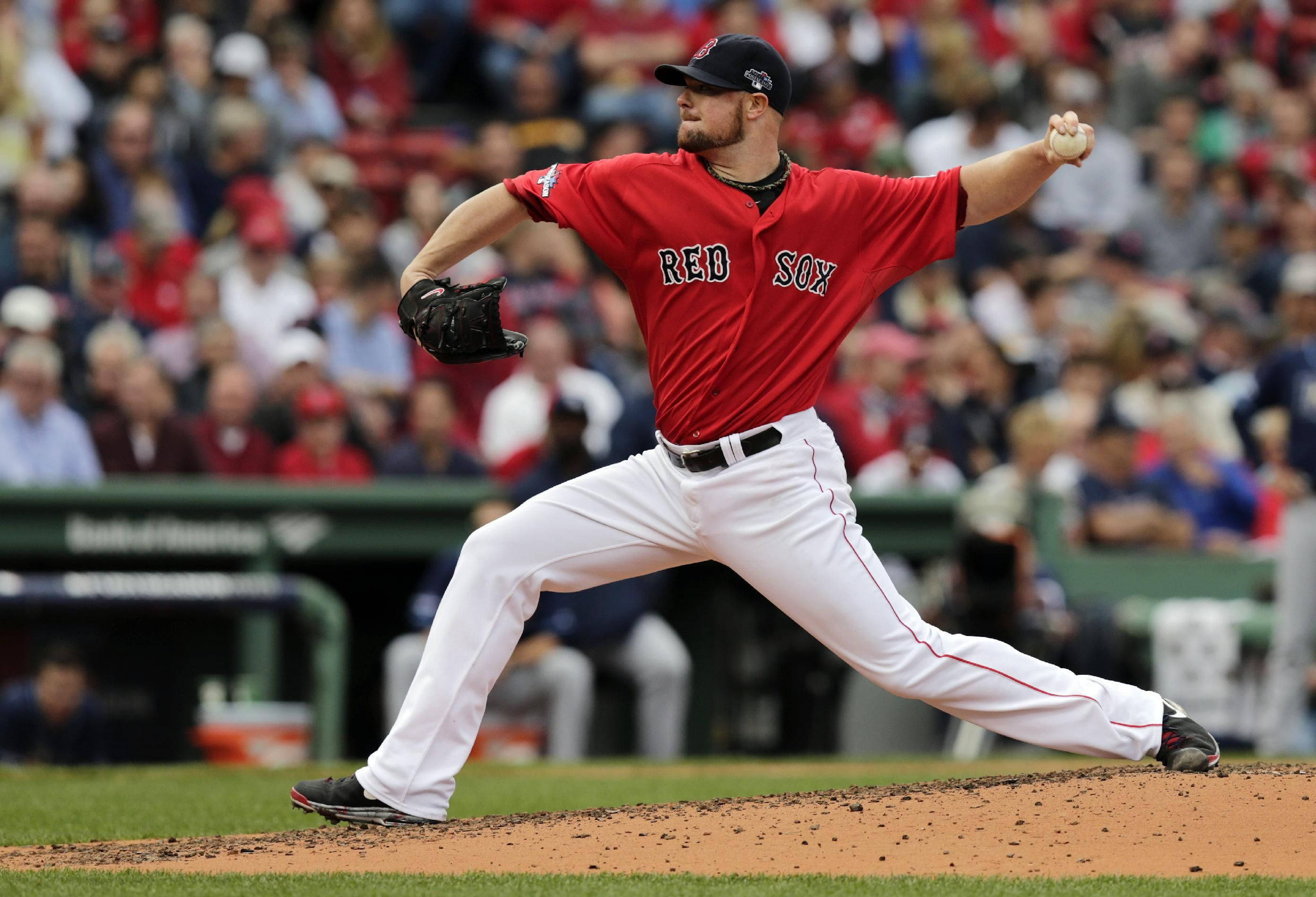 Boston Red Sox 桌布 壁紙 — 一名身穿紅色紅襪隊球衣的棒球投手，在陽光明媚的投手丘上投球，背景是模糊的人群。