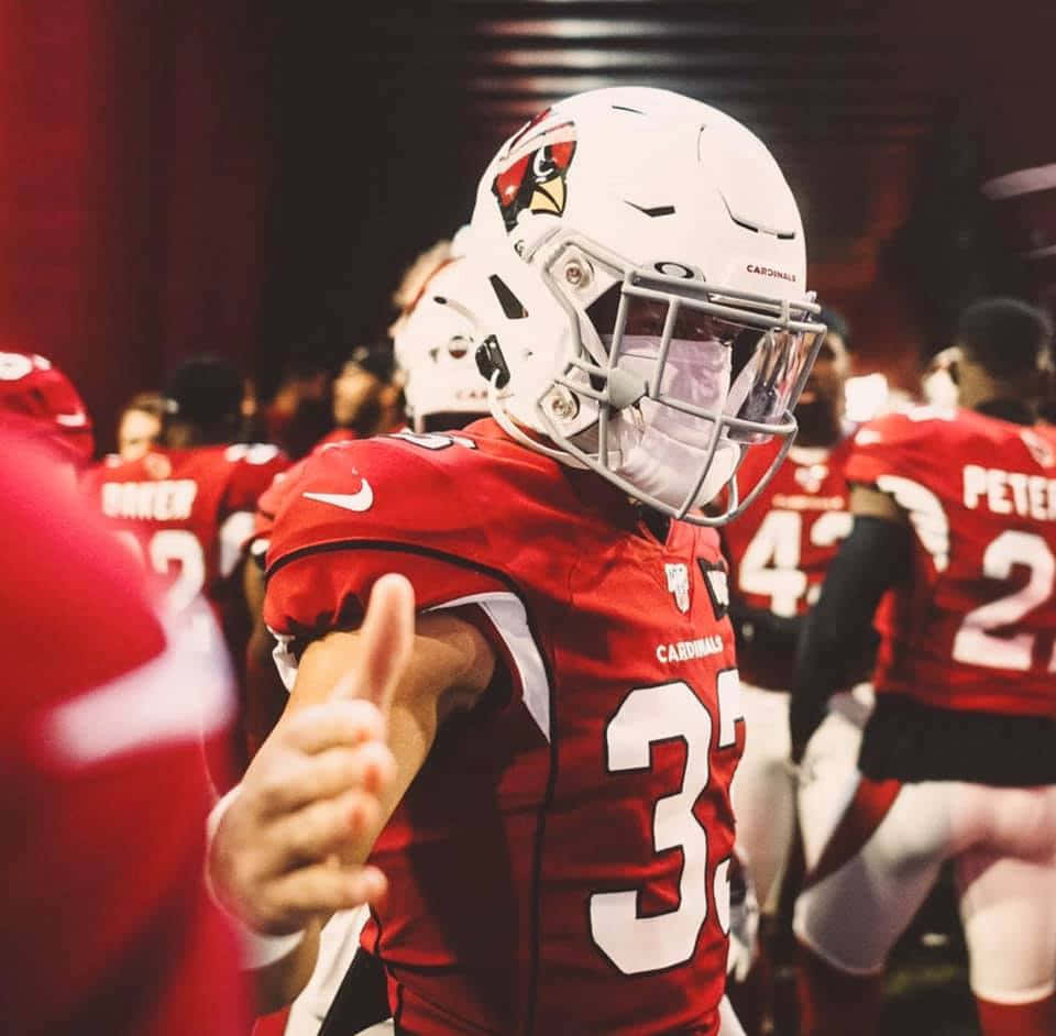 Byron Murphy 桌布 壁紙 — 一名身穿紅色紅雀隊球衣的足球員，戴著帶有球隊標誌的白色頭盔，豎起大拇指。