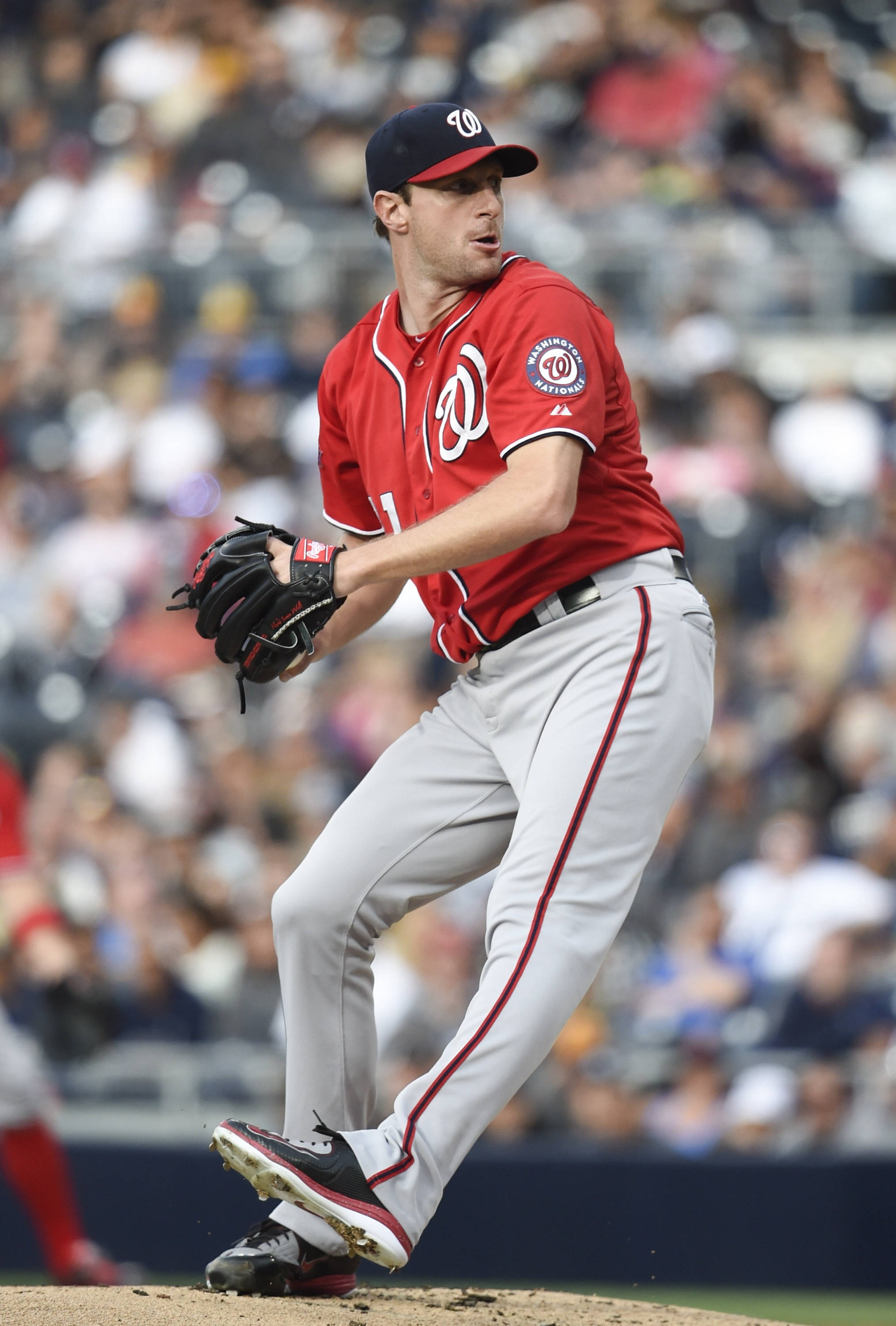 Max Scherzer 桌布 壁紙 — 一名身穿紅色華盛頓國民隊球衣的棒球投手在日間比賽中在投手丘上揮臂，背景是模糊的人群。